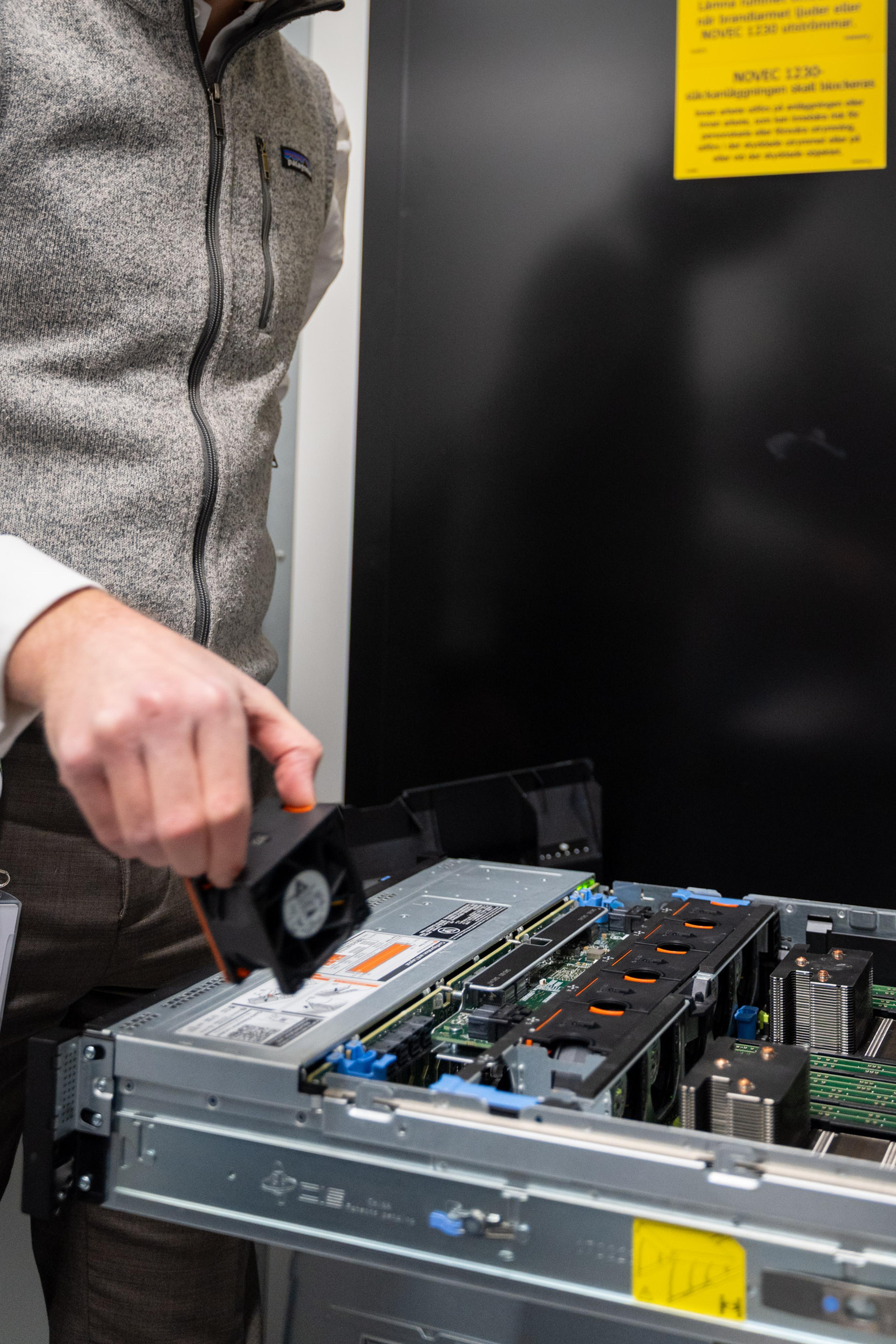 Tekniker åpner servermaskinvare med verktøy for vedlikehold og reparasjon av IT-utstyr.