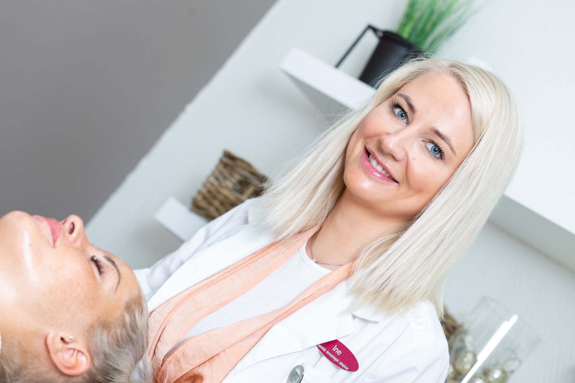 Tannlege behandler pasient i klinikkstol under moderne tak- og vegglys.