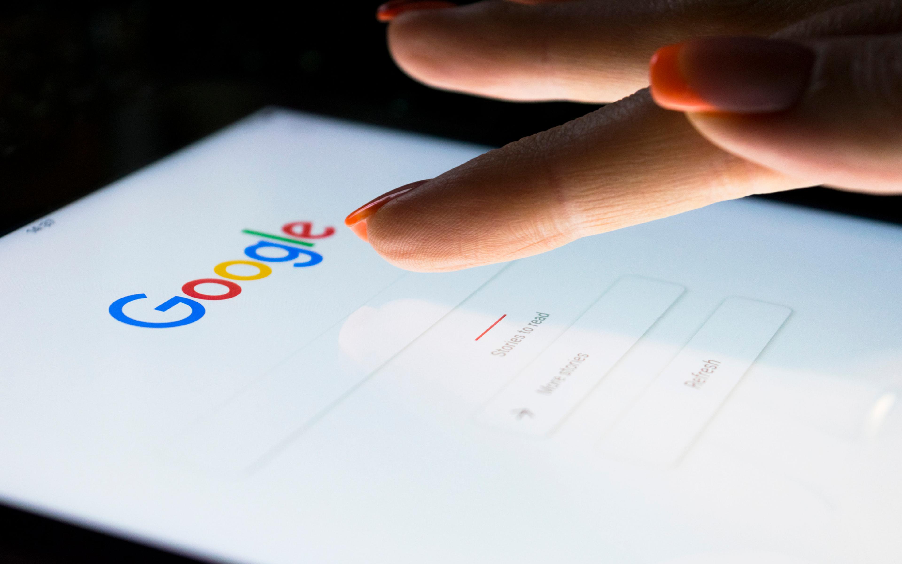 Finger som klikker på Google-logoen på en tablet, illustrerer søkemotoroptimalisering og teknisk SEO