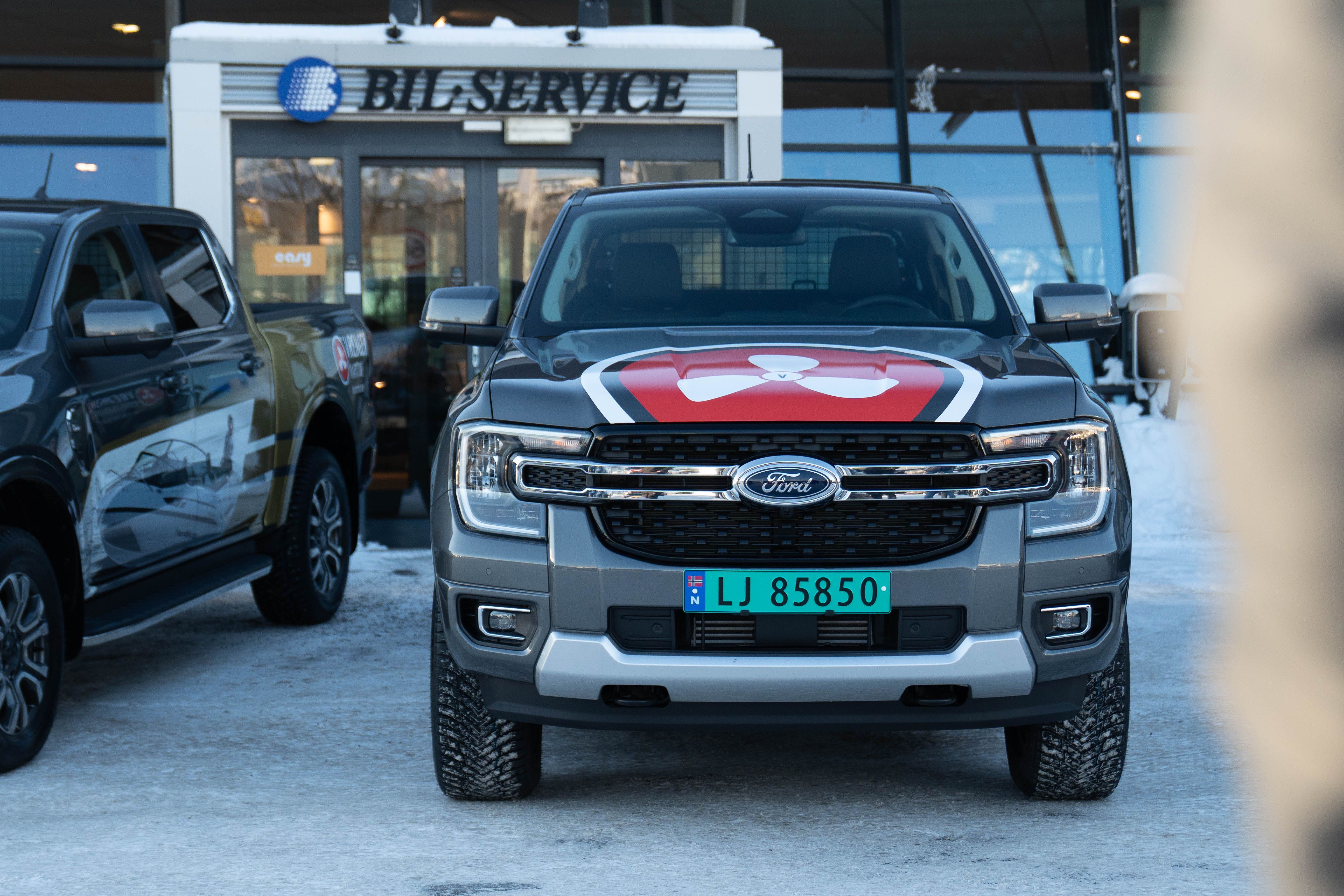 Ford Expedition profilert med rødt og hvitt design parkert foran serviceverksted, markedsføringsprosjekt for Vrengen Maritime.