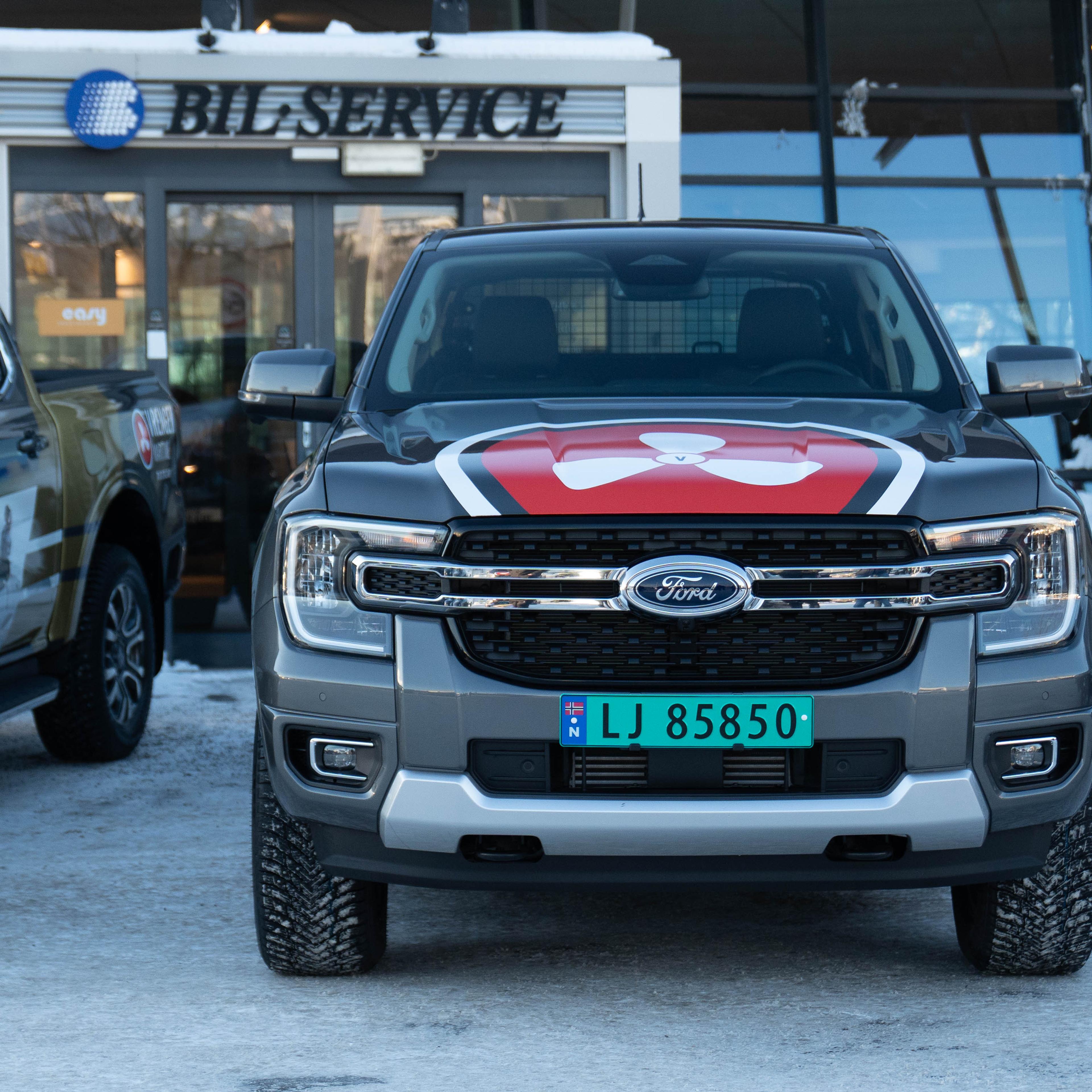 Ford Expedition profilert med rødt og hvitt design parkert foran serviceverksted, markedsføringsprosjekt for Vrengen Maritime.