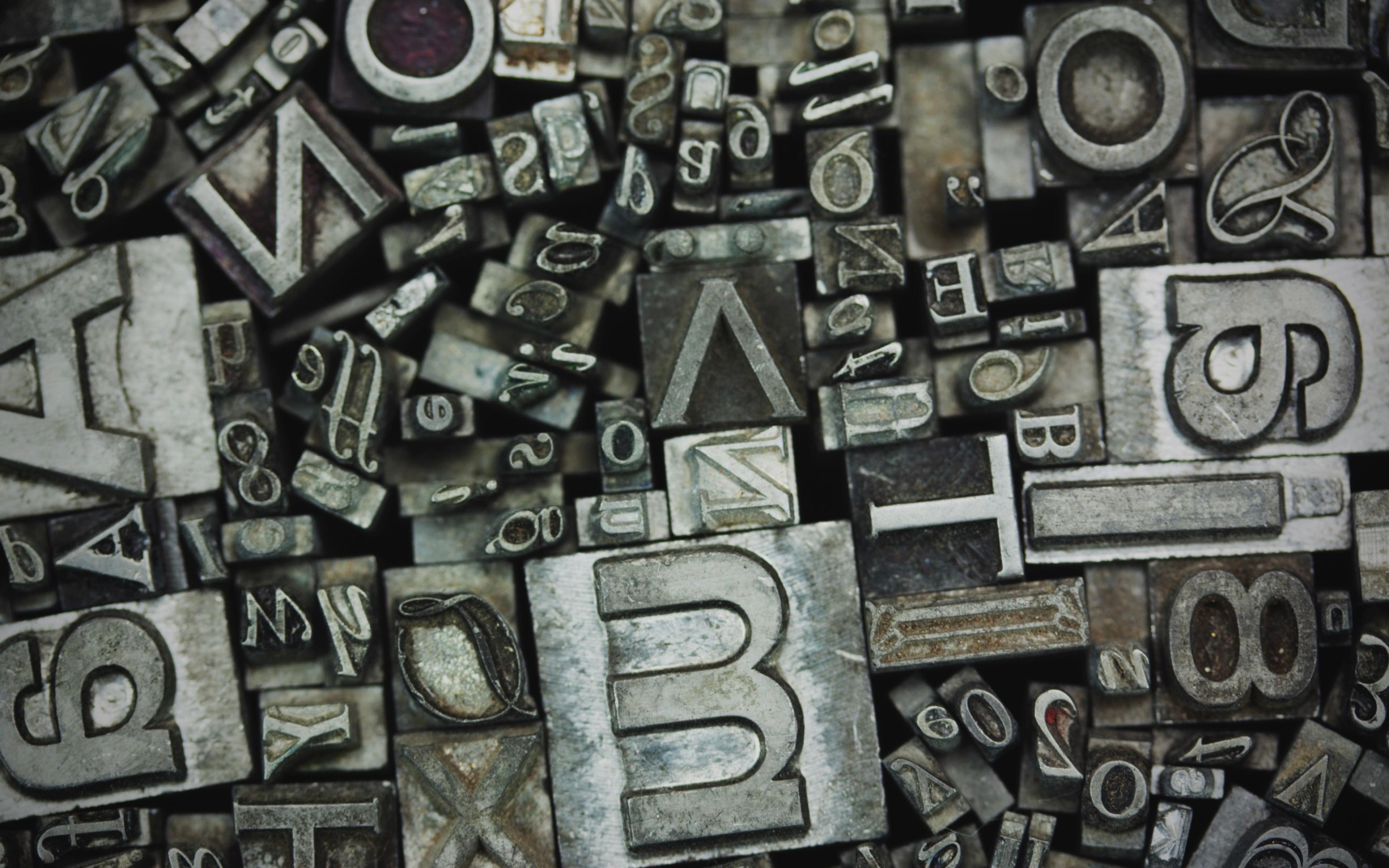 Metall typografibokstaver og tall ordnet som dekorasjon, illustrerer designelementer som logoer og typografi