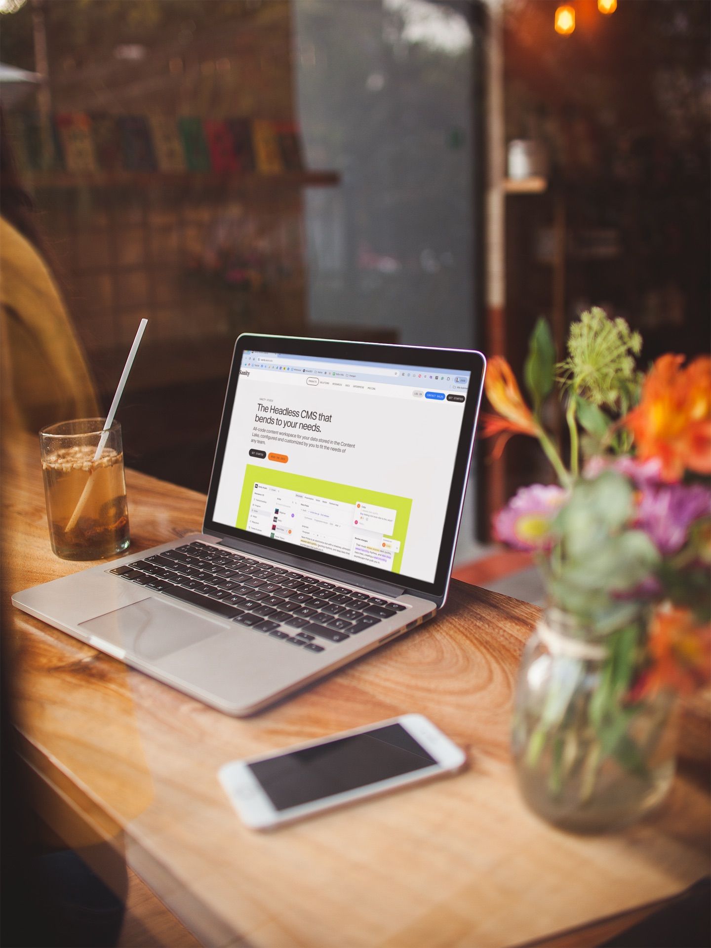 Laptop som viser Sanity headless CMS-grensesnittet, omgitt av grønn natur — symboliserer moderne, fleksibel innholdshåndtering