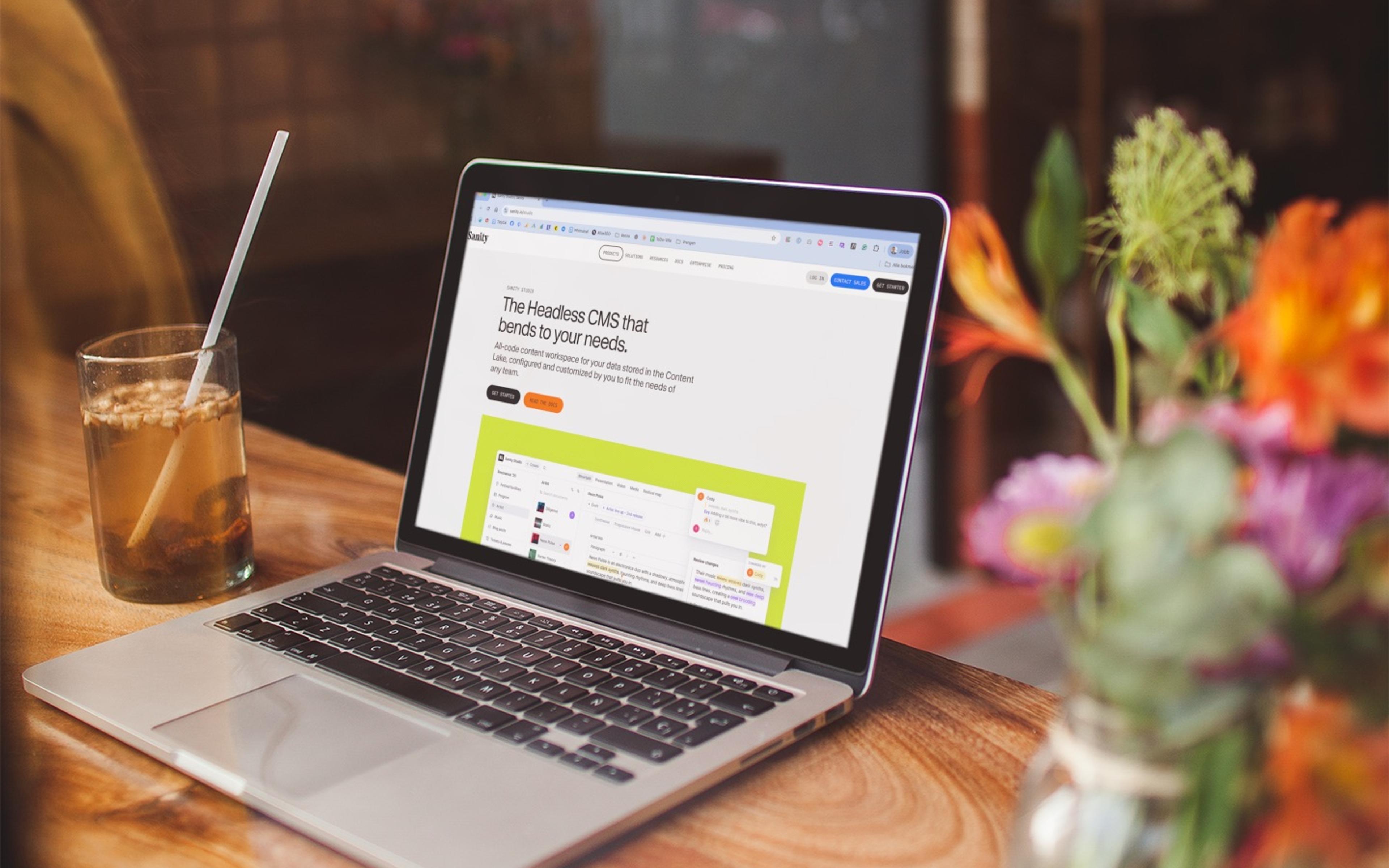 Laptop som viser Sanity headless CMS-grensesnittet, omgitt av grønn natur — symboliserer moderne, fleksibel innholdshåndtering