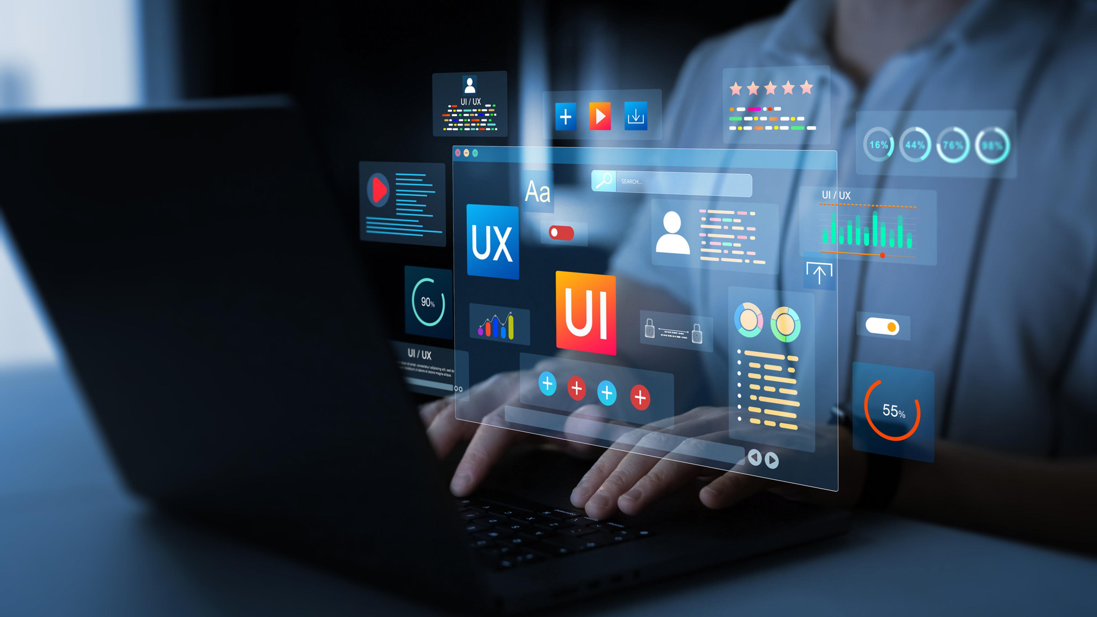 Utvikler viser holografiske UI- og UX-designelementer med ikoner for brukergrensesnitt, analyser og stjerneanmeldelser på glassplate over tastatur.