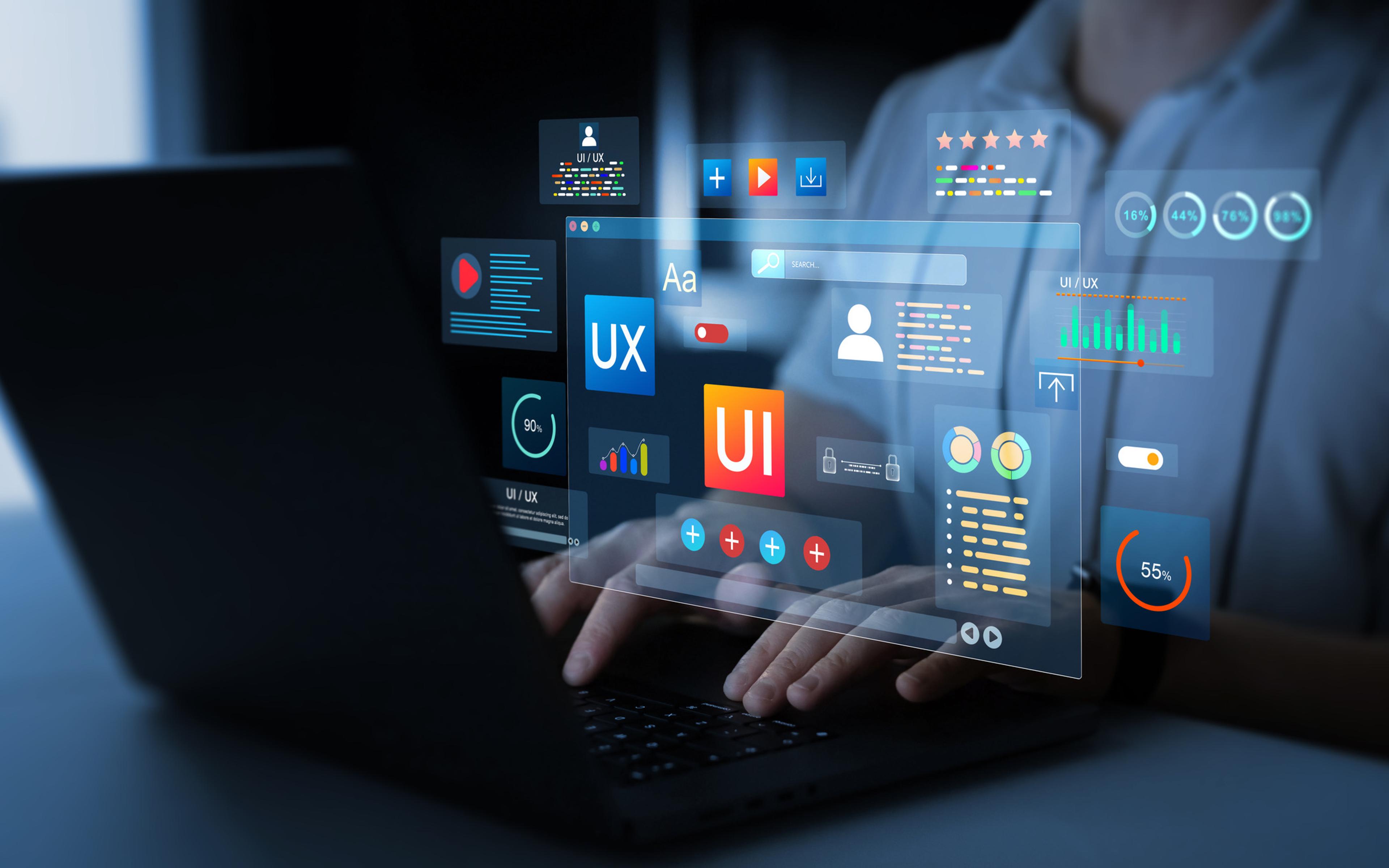 Utvikler viser holografiske UI- og UX-designelementer med ikoner for brukergrensesnitt, analyser og stjerneanmeldelser på glassplate over tastatur.