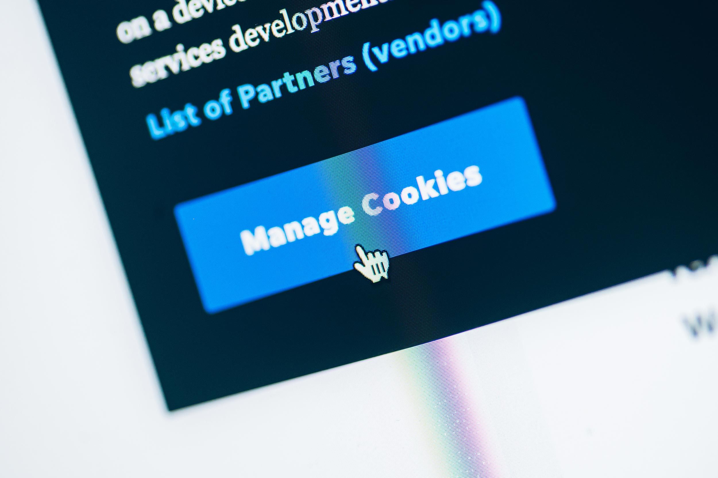 Blå "Manage Cookies"-knapp på skjerm med musepeker, illustrerer cookie-håndtering i Google Consent Mode V2.