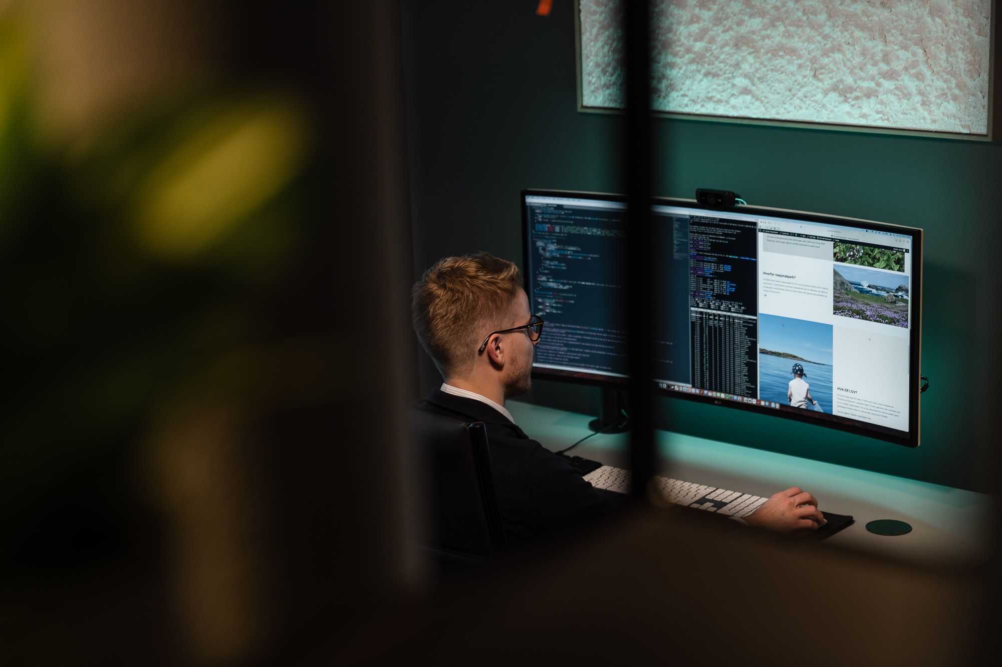 Mann ved skjerm arbeider med webdesign og koding i digitalt arbeidsmiljø.