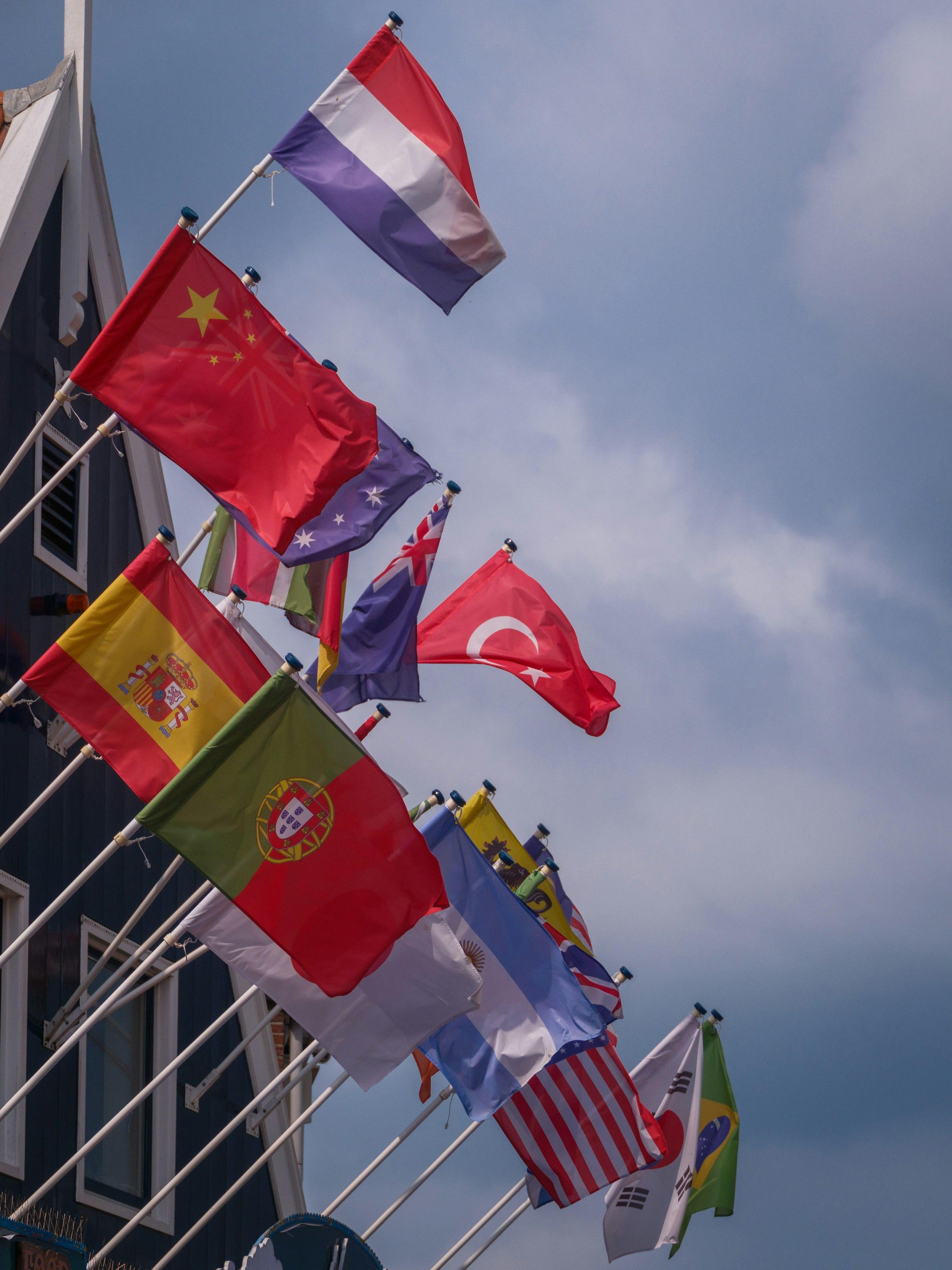 National flags flying against a cloudy sky
