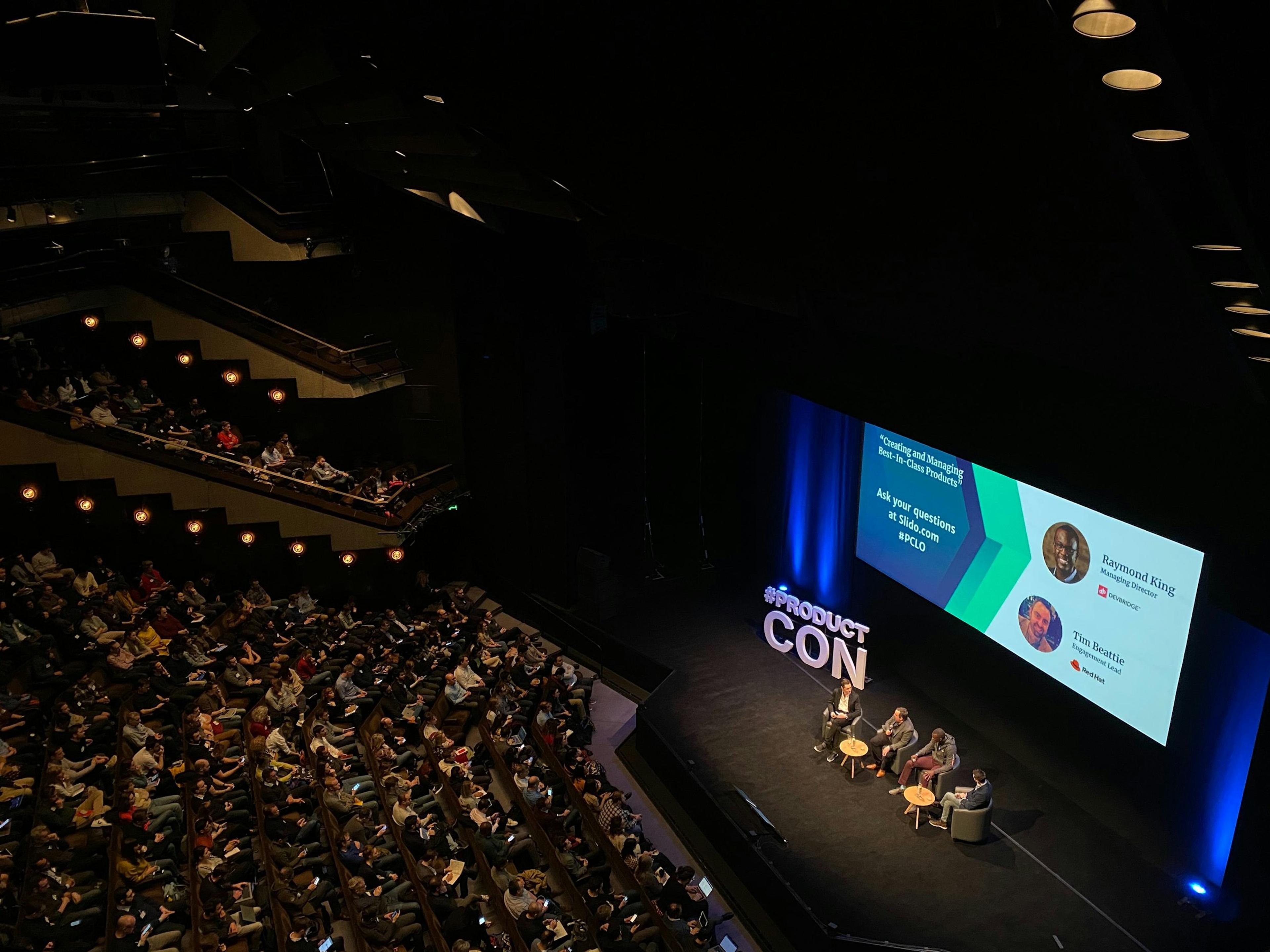 A panel discussion on stage in a large auditorium