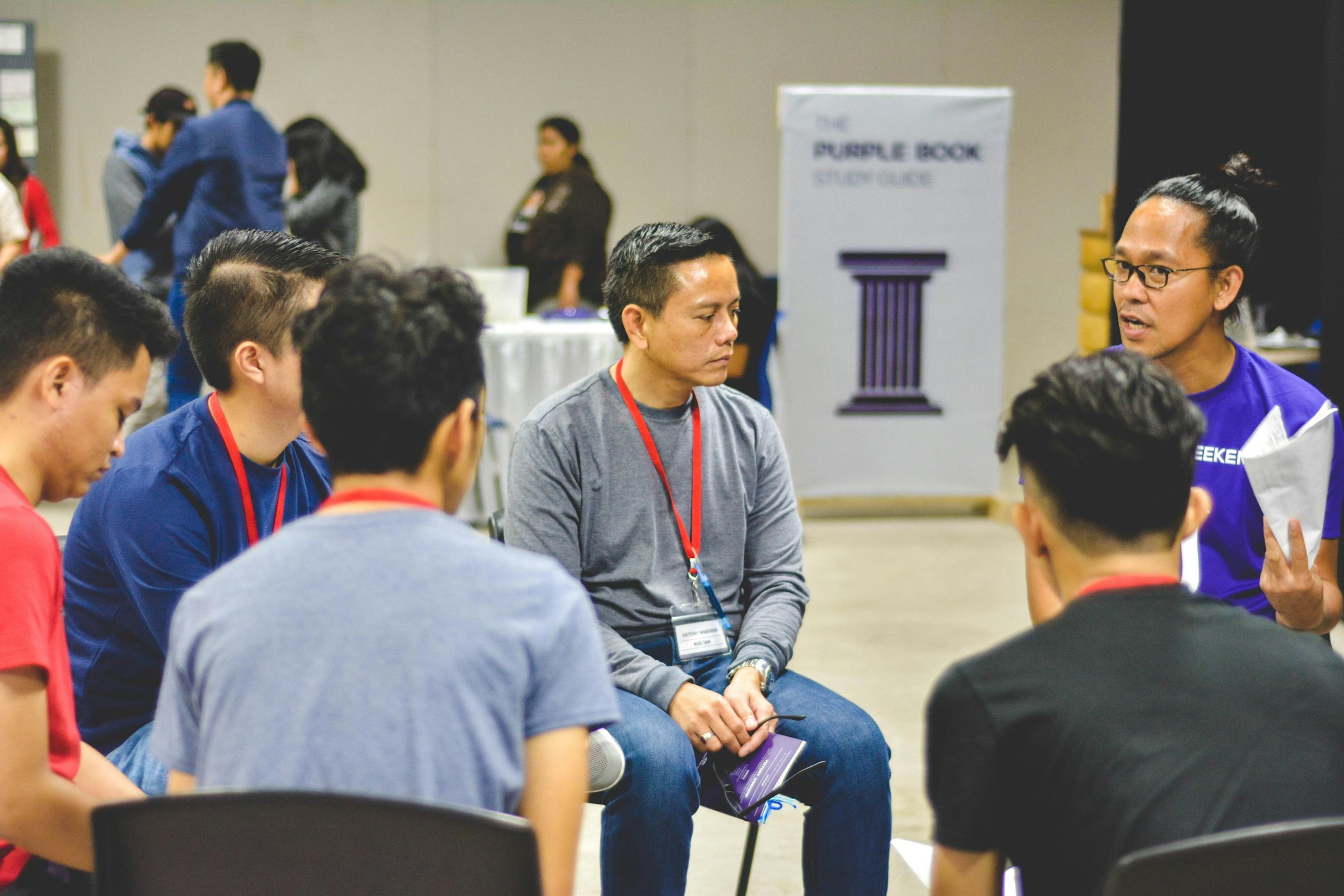 A group of people in conversation, seated in a circle