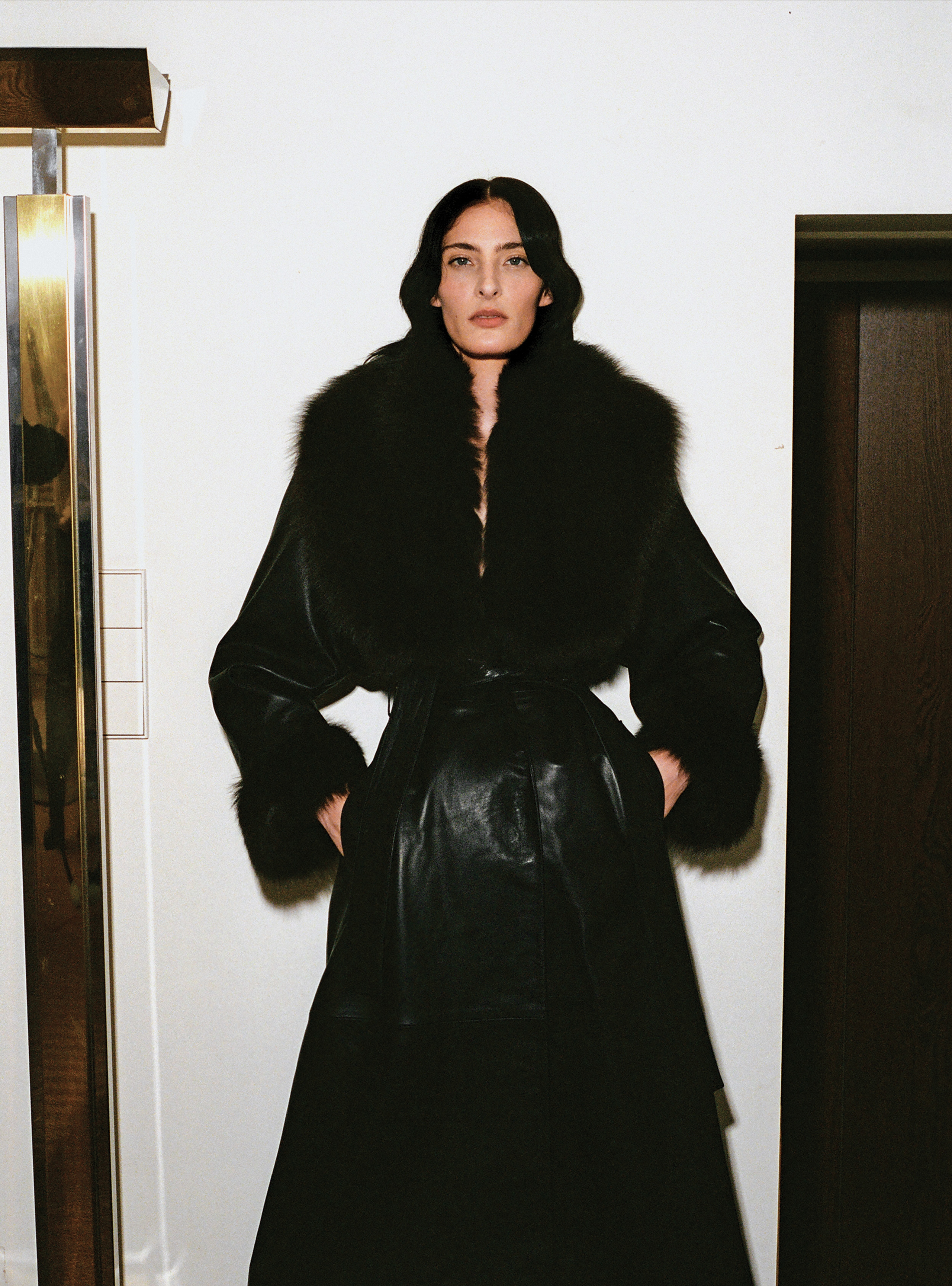A model wearing the Freja Black Dark Chocolate mid-length leather trench