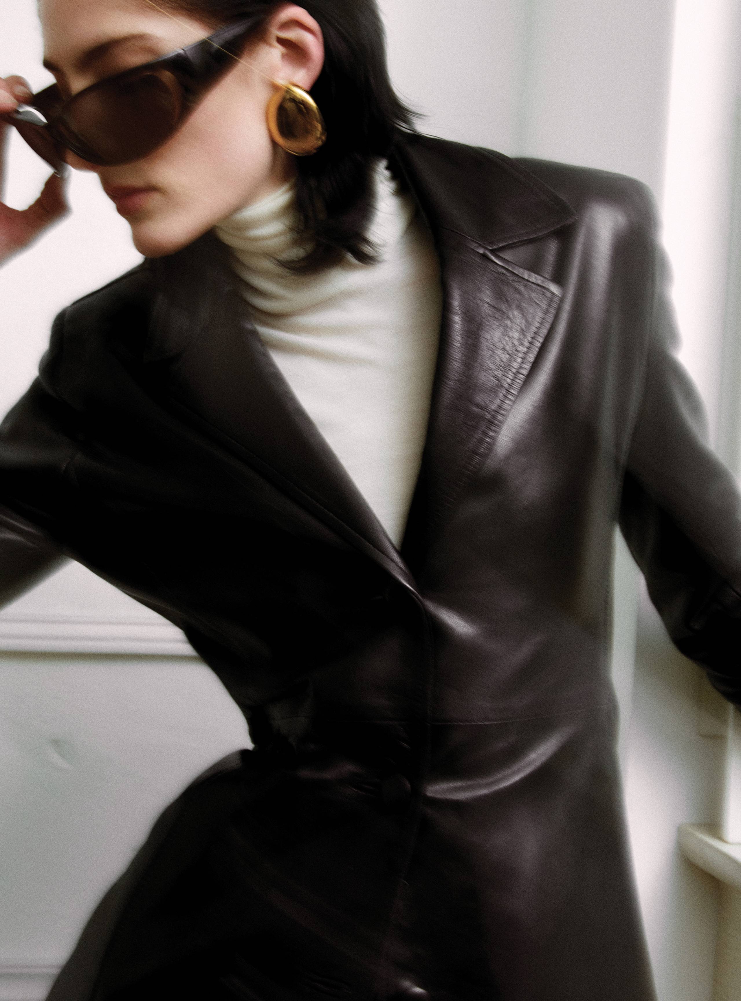 A model holding her sunglasses wearing the Winona Black fitted leather jacket