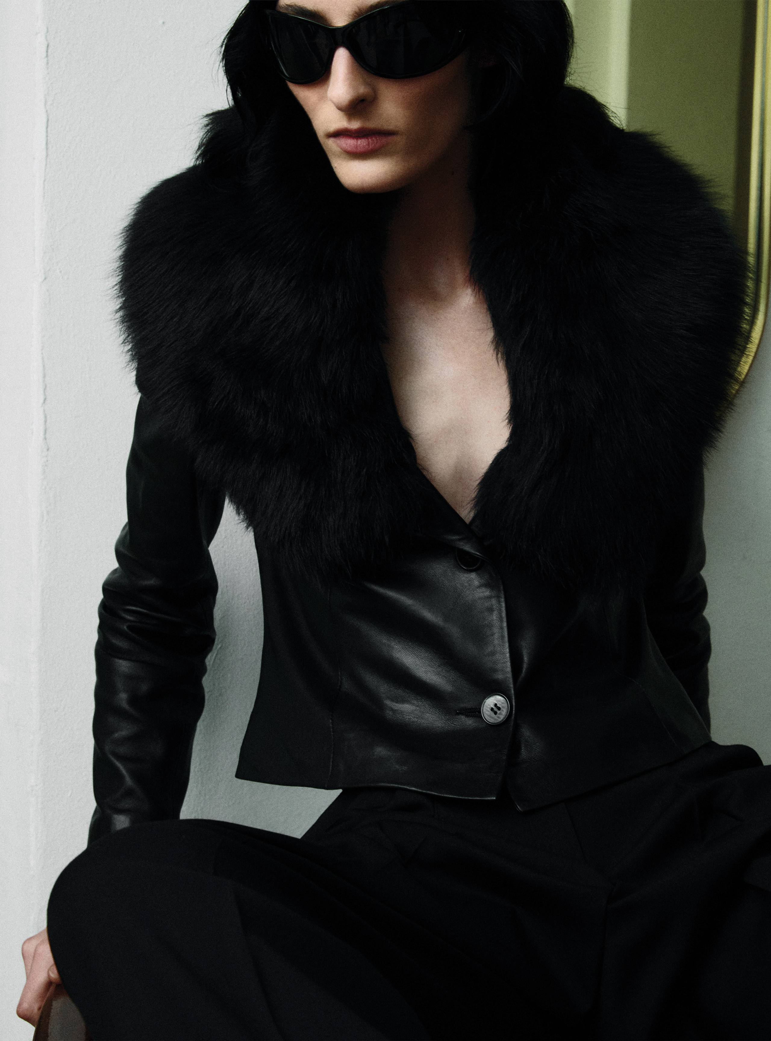 A model sitting wearing the Amber Black jacket