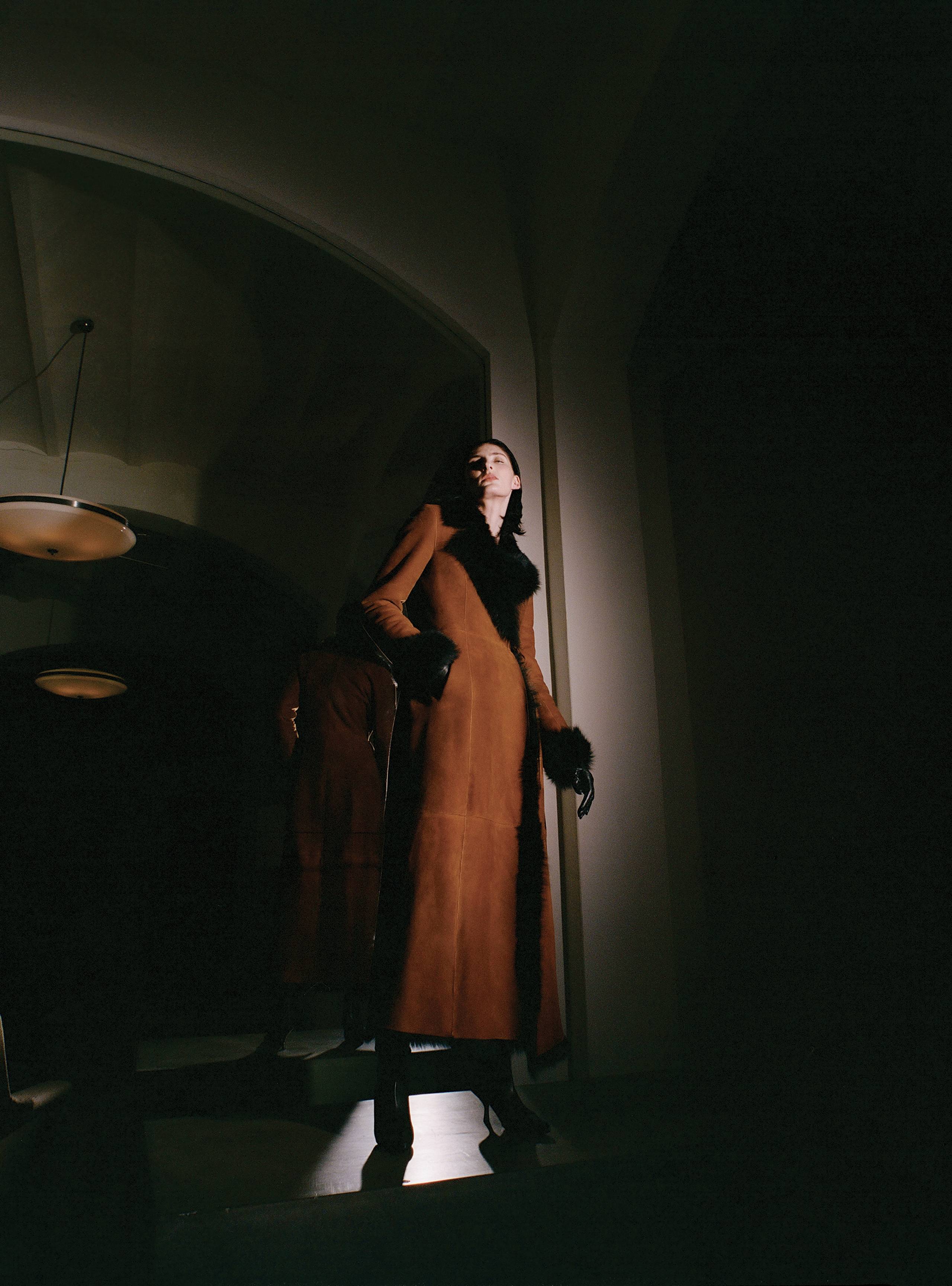 A model standing wearing the Joni Cognac long shearling coat