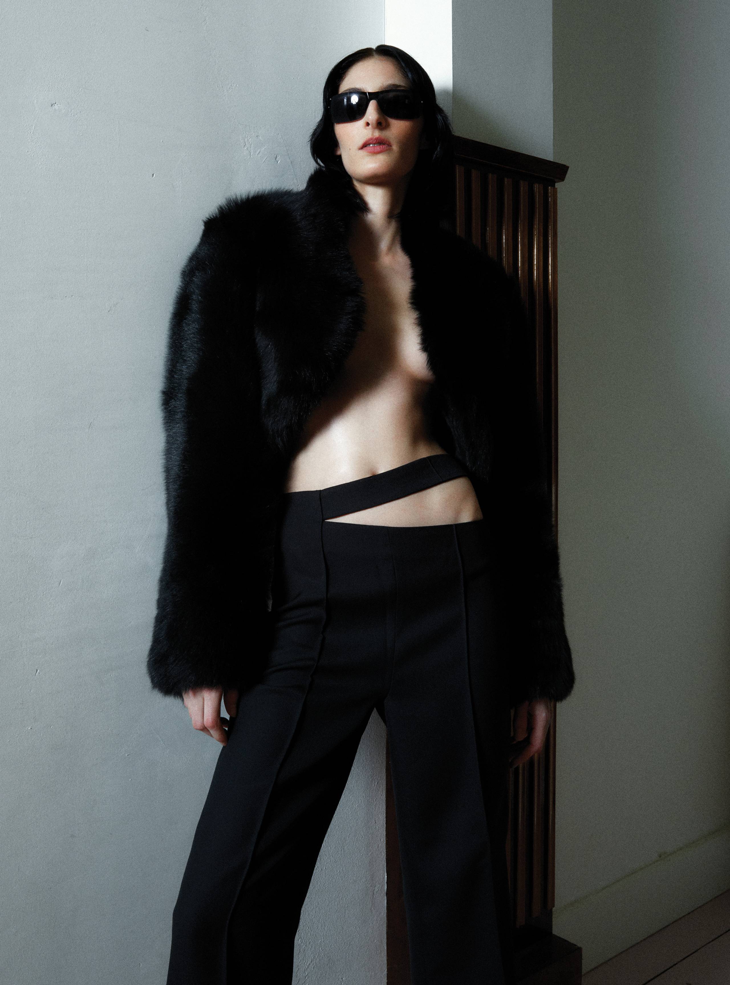 A model standing wearing the Black Bolero luxurious shearling jacket