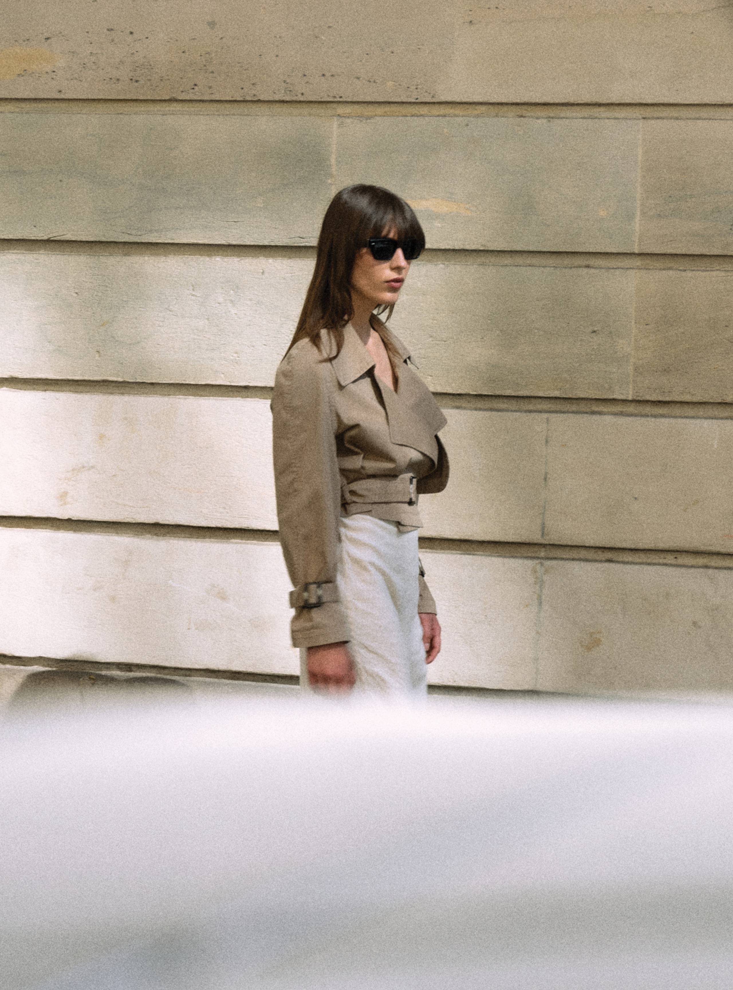 A model standing sideways in a building in the Hatti Canvas Khaki relaxed cropped fabric jacket