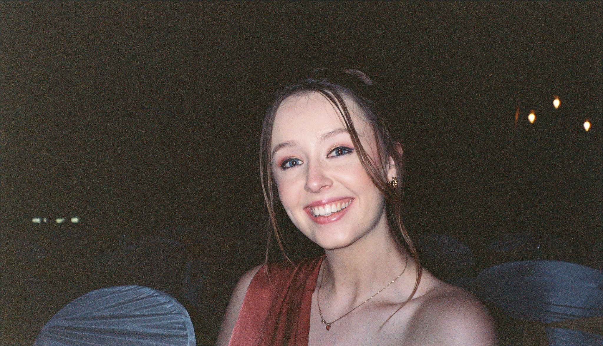 A disposable camera picture of a girl on an evening at a wedding with flash photography. 
