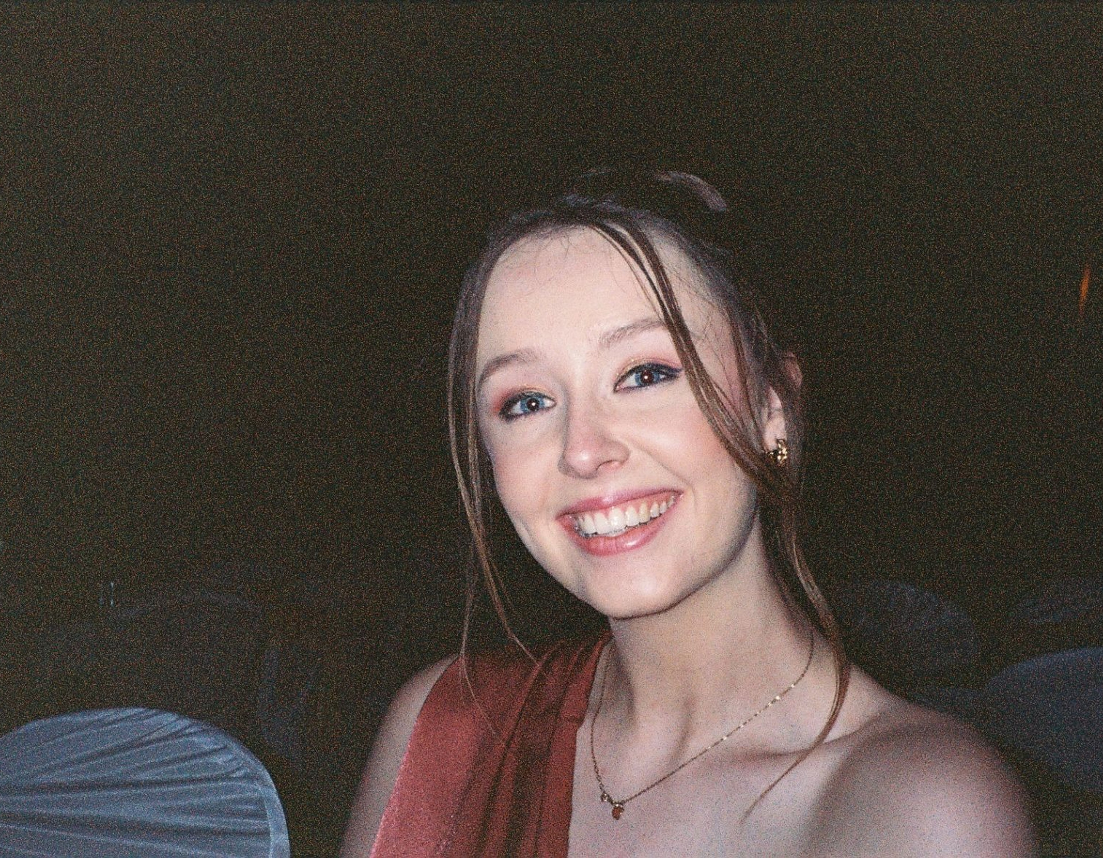 A disposable camera picture of a girl on an evening at a wedding with flash photography.