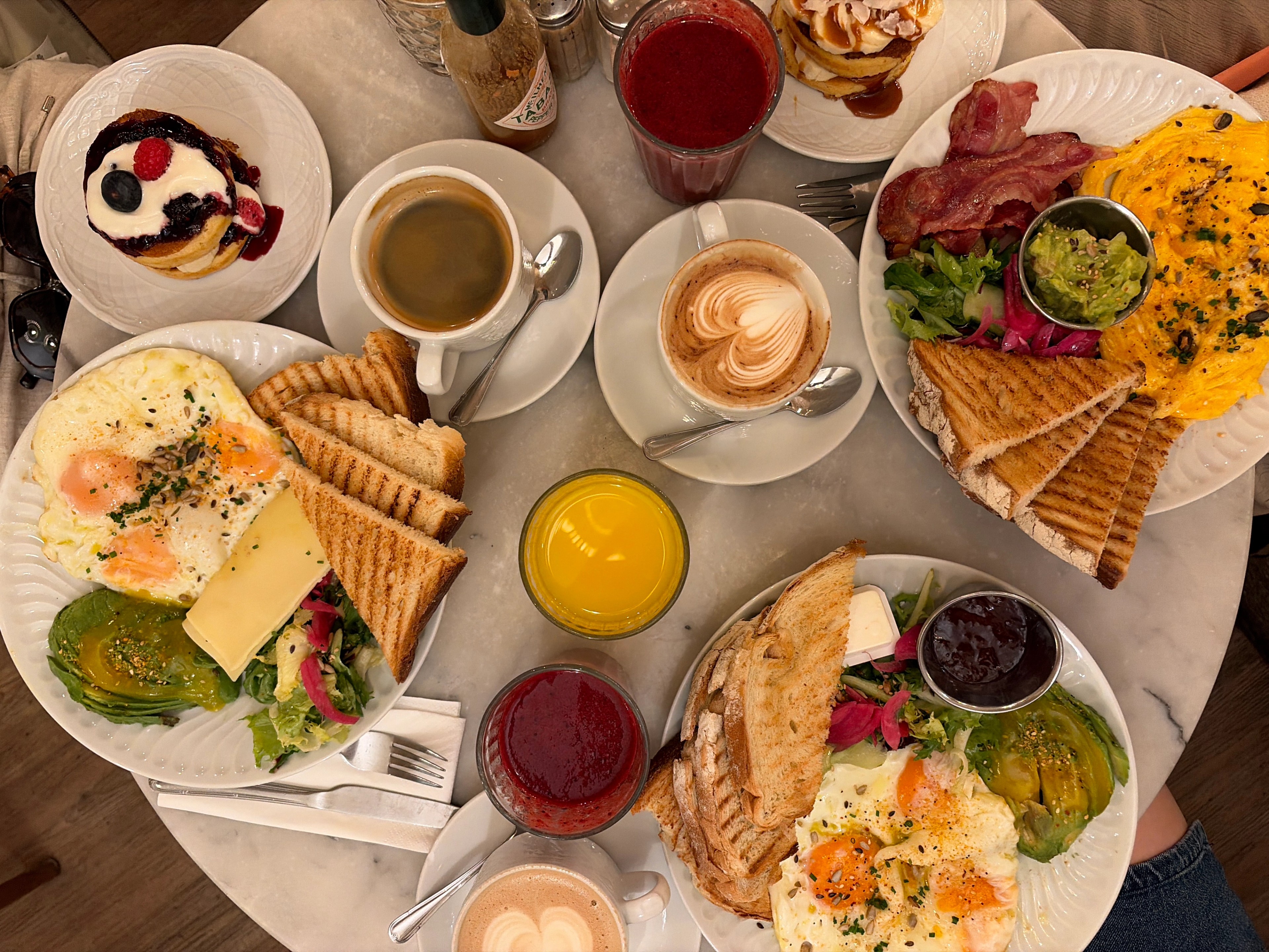brunch food in Lisbon, table full of coffee juice, toast and eggs