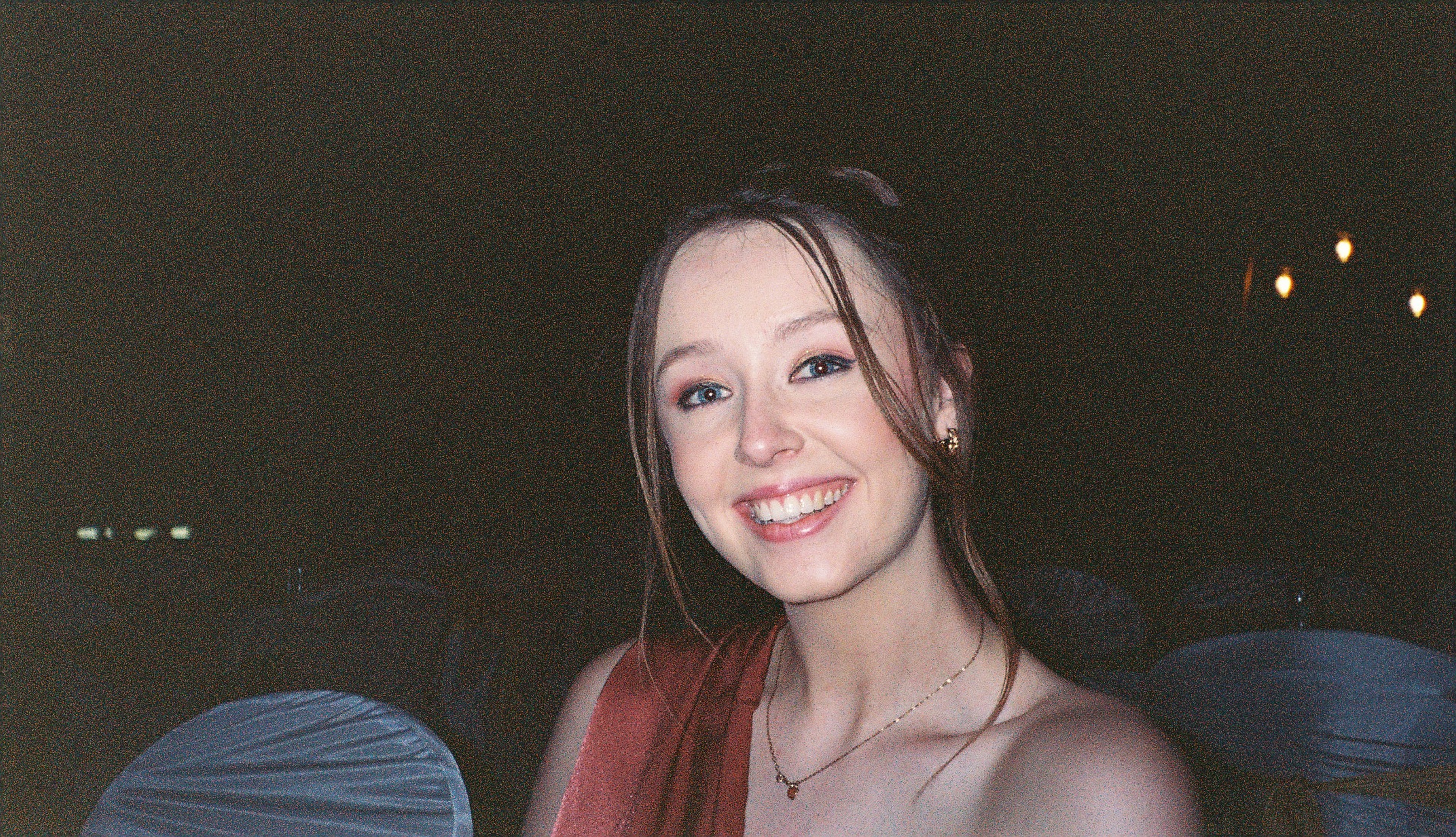 A disposable camera picture of a girl on an evening at a wedding with flash photography. 