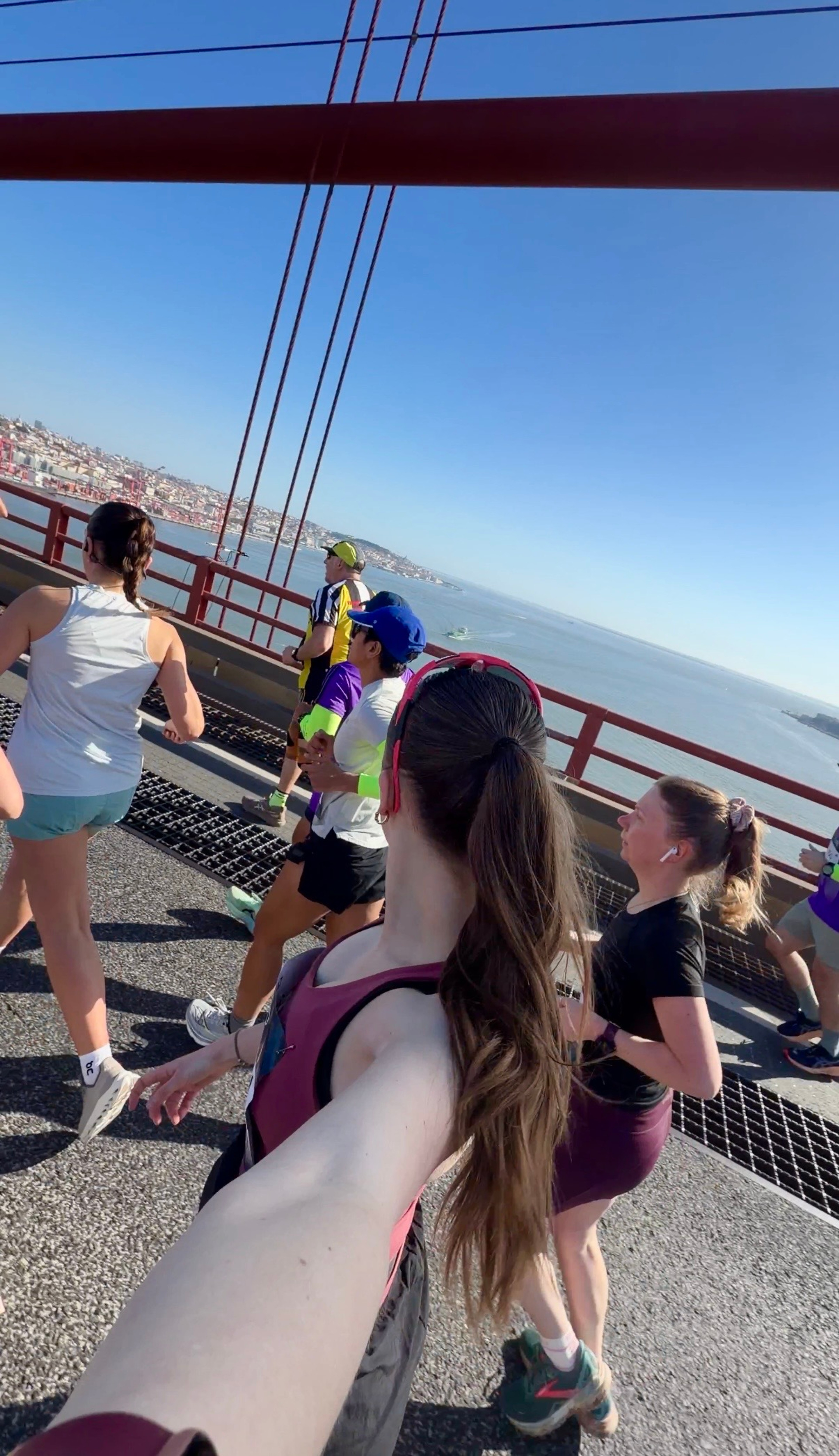 Girl running a half marathon in Lisbon, running over a bridge