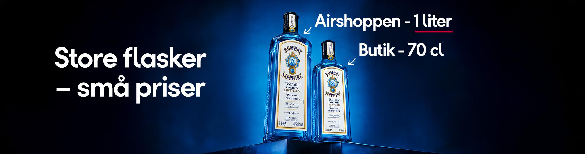 Two Bombay Sapphire gin bottles, a 1-liter bottle labeled "Airshoppen" and a 70cl bottle labeled "Butik," with text "Store flasker – små priser" (Large bottles – small prices).