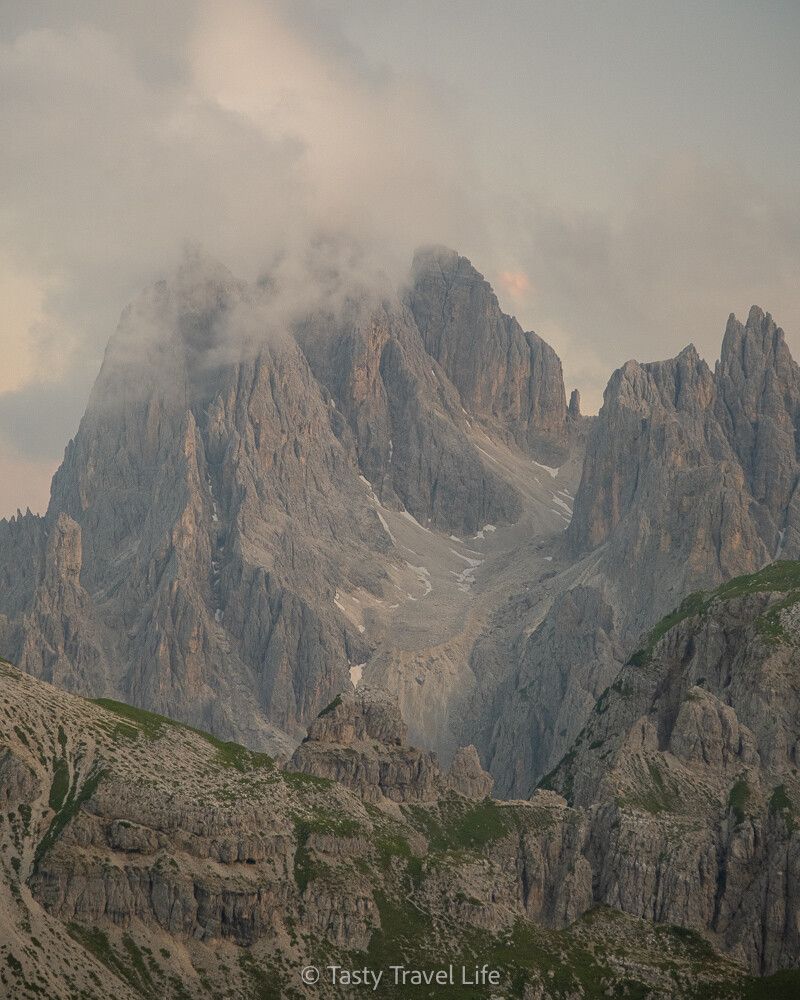 Photo zoomée des sommets gris avec un nuage au-dessus.