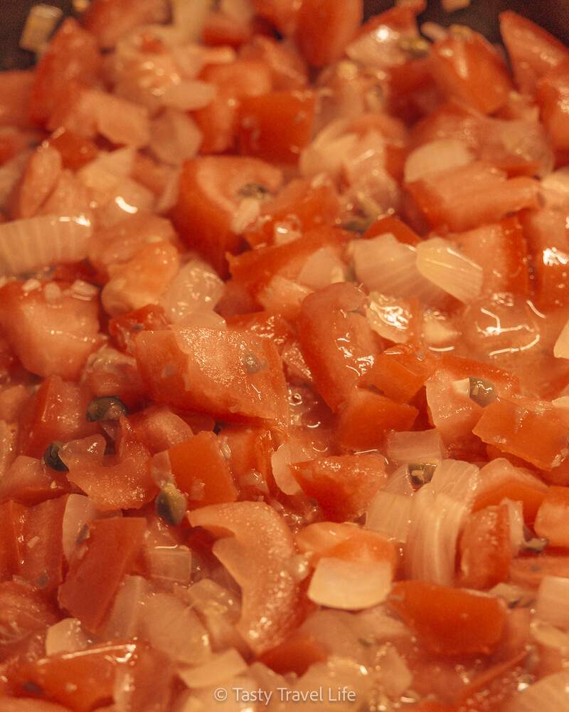 sauce pour pâtes fraîches dans une poêle. Tomates, câpres, oignon et ail.