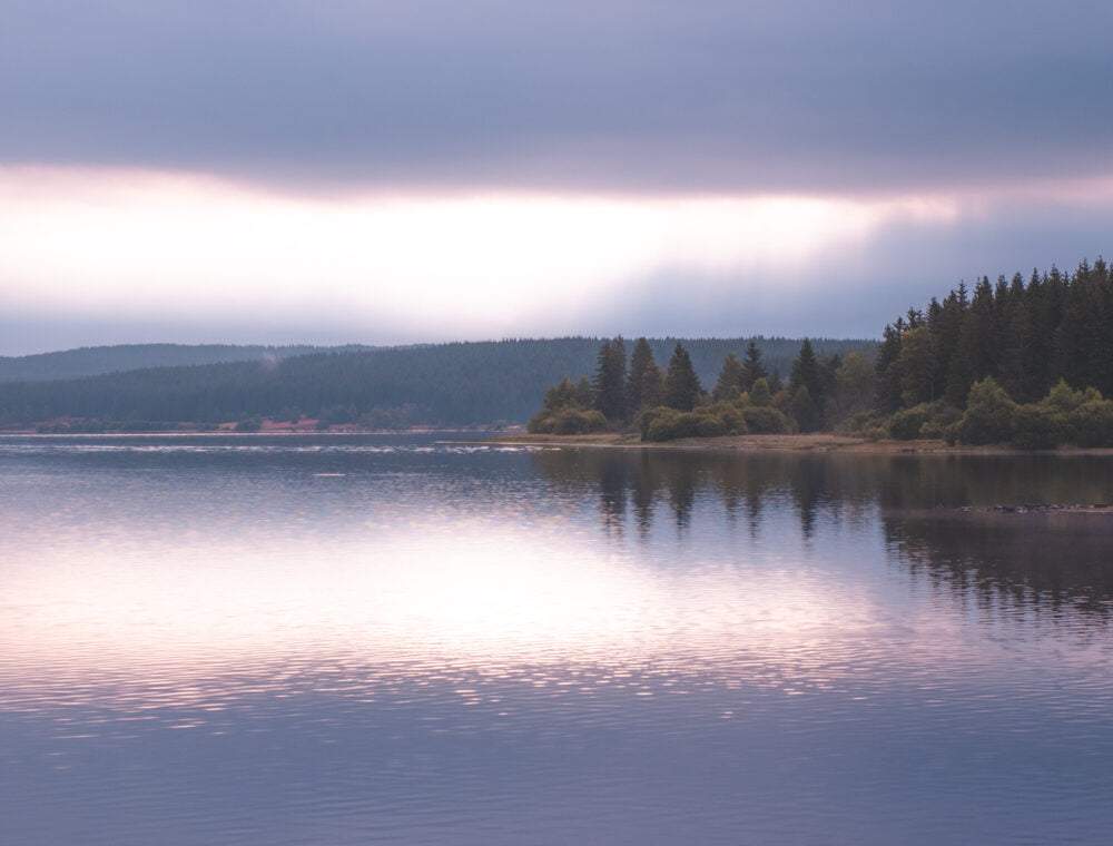rain clouds and sunset above lac de charpal lozere france