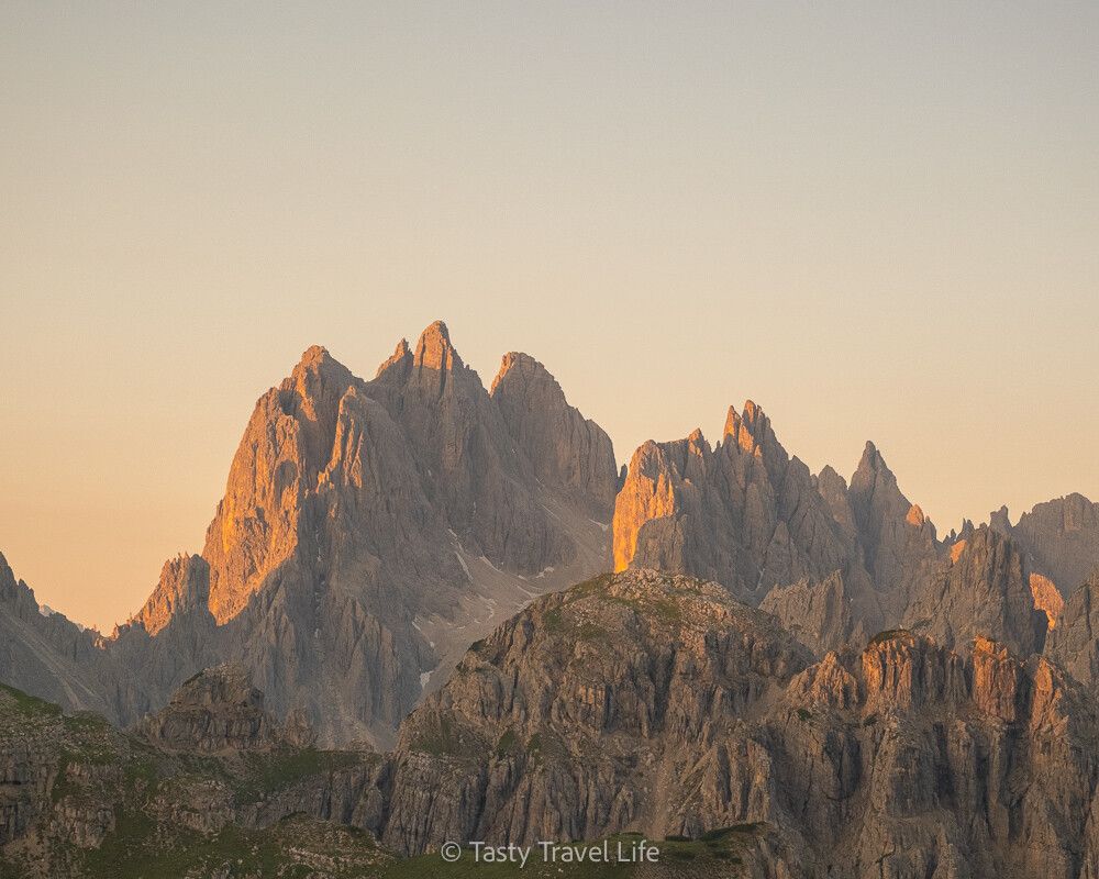 Lever de soleil sur les sommets, couleurs orangées et pics acérés au Rifugio Auronzo