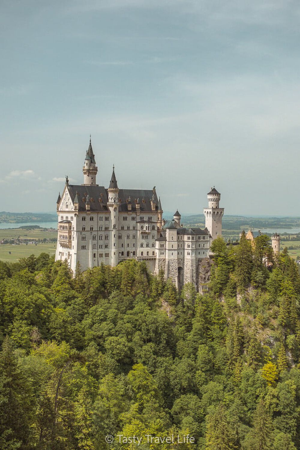 Neuschwanstein Fairytale castle on the hill with views of the land behind