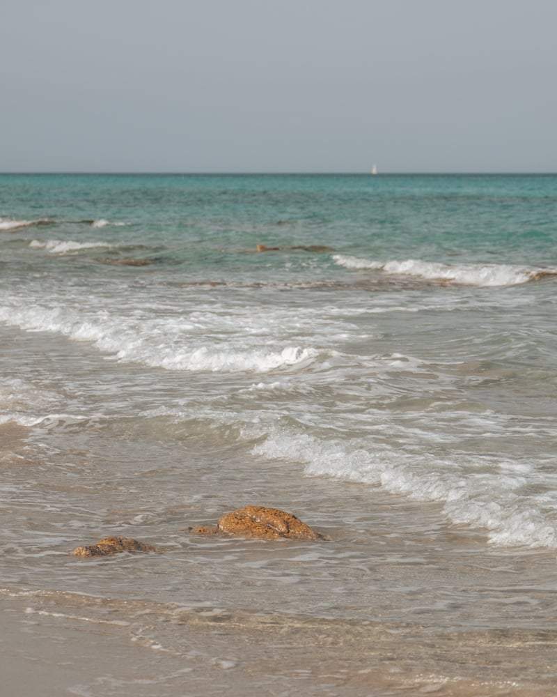 Kristalhelder water en rotsen bij het strand van Berchida