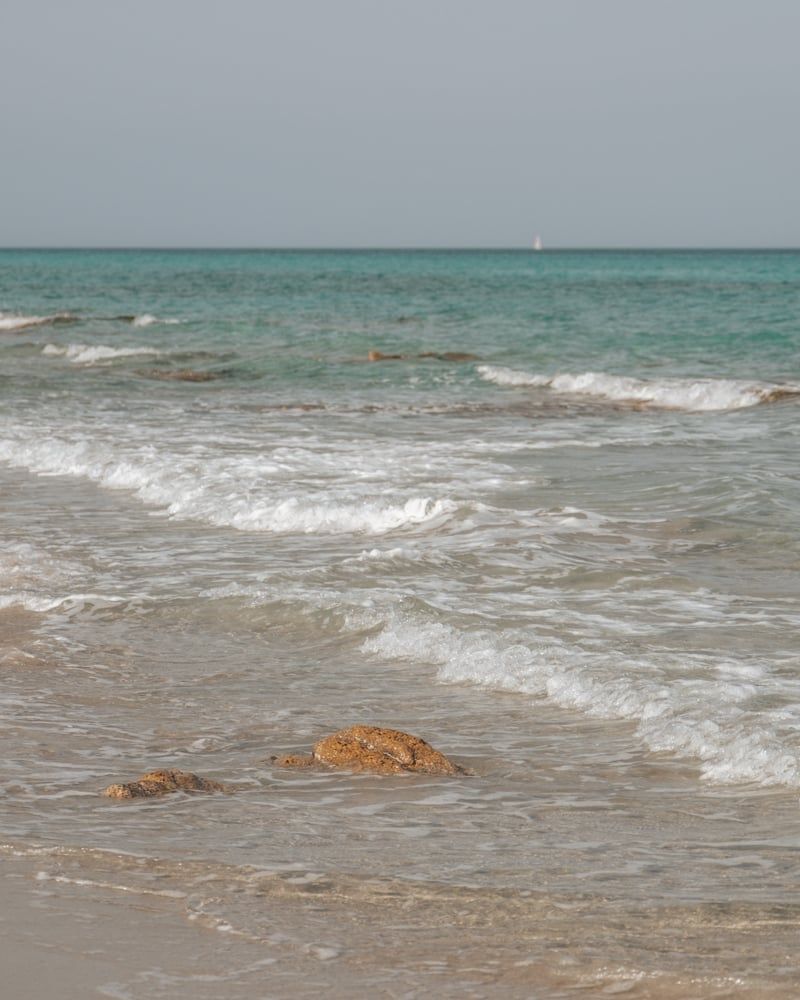 Kristalhelder water en rotsen bij het strand van Berchida