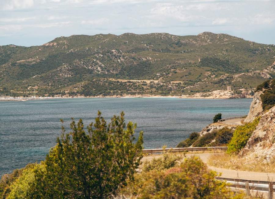 Camperavontuur op Sardinië over wegen met uitzicht op kliffen, het strand en blauw water.