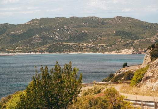 Sardinia motorhome adventure roads with views of cliffs, beach and blue water.