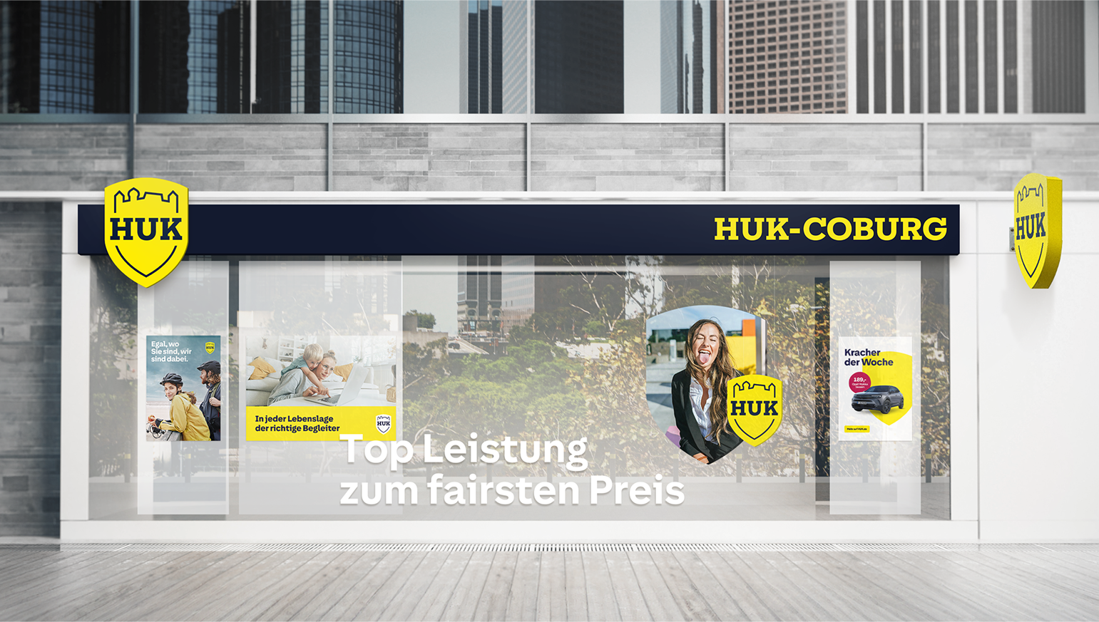 Fotorealistisches Mockup einer HUK-Geschäftsstelle mit großer Schaufensterbeklebung im neuen gelb-weißen Markendesign
