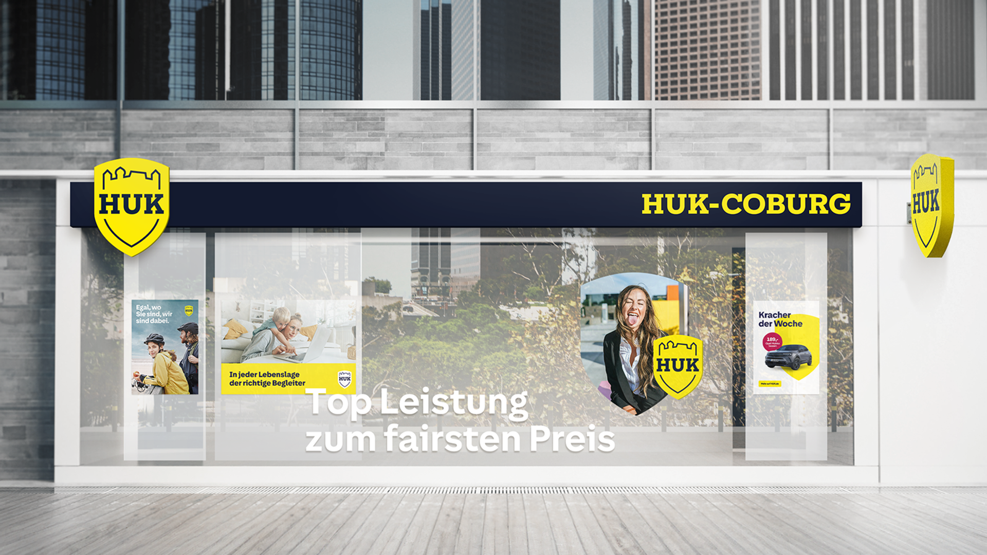 Fotorealistisches Mockup einer HUK-Geschäftsstelle mit großer Schaufensterbeklebung im neuen gelb-weißen Markendesign