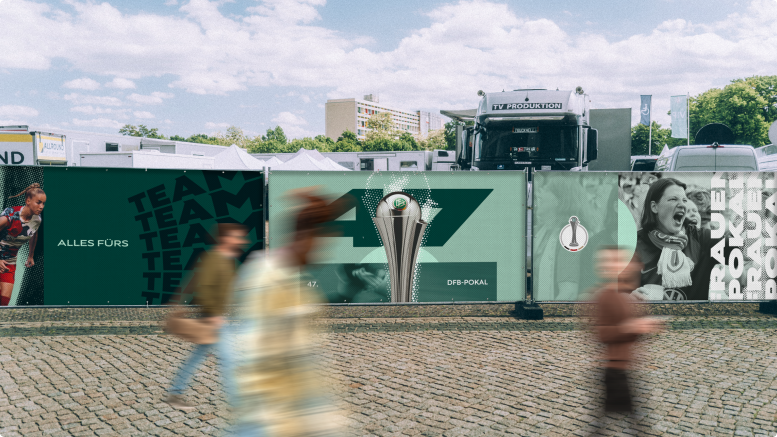 Bauzaun-Bespannung für den Frauen DFB-Pokal mit dem Slogan Alles fürs Team und Pokalgrafik. 