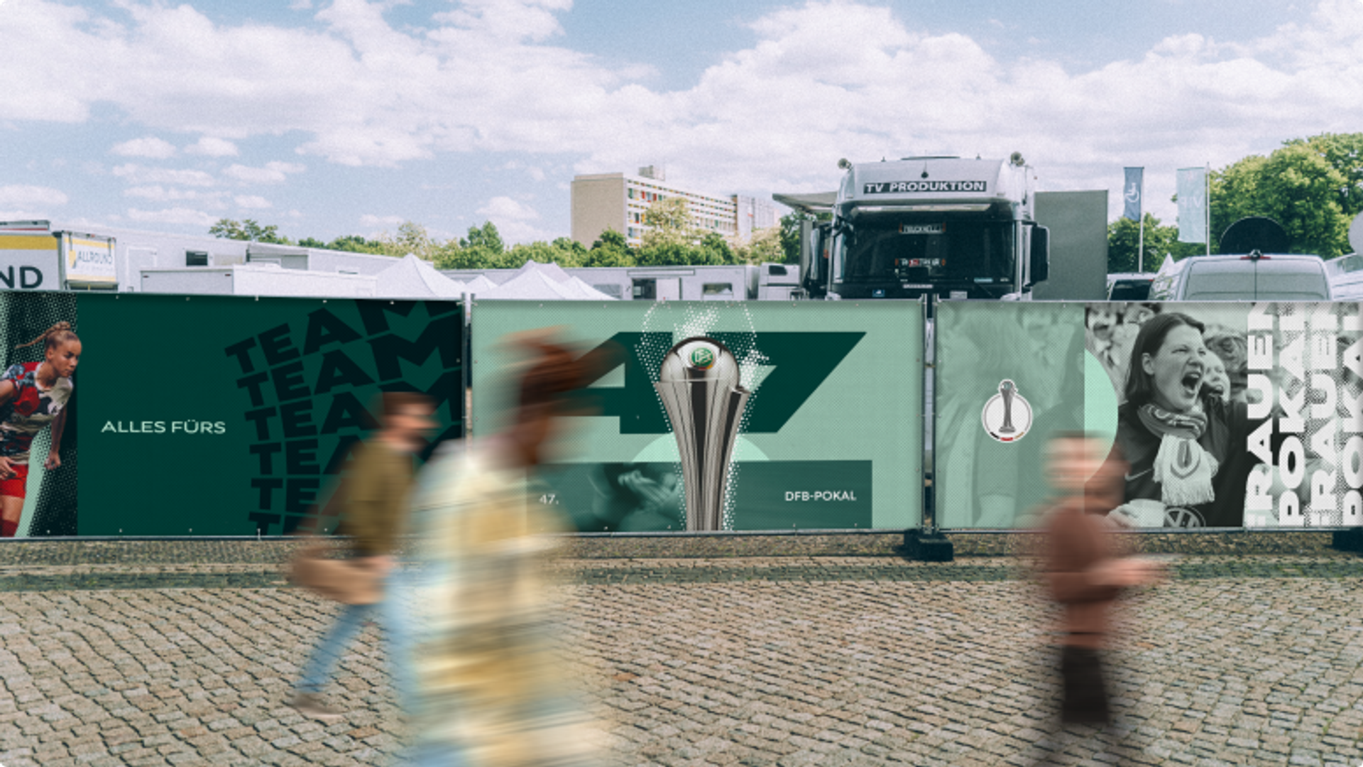 Bauzaun-Bespannung für den Frauen DFB-Pokal mit dem Slogan Alles fürs Team und Pokalgrafik.