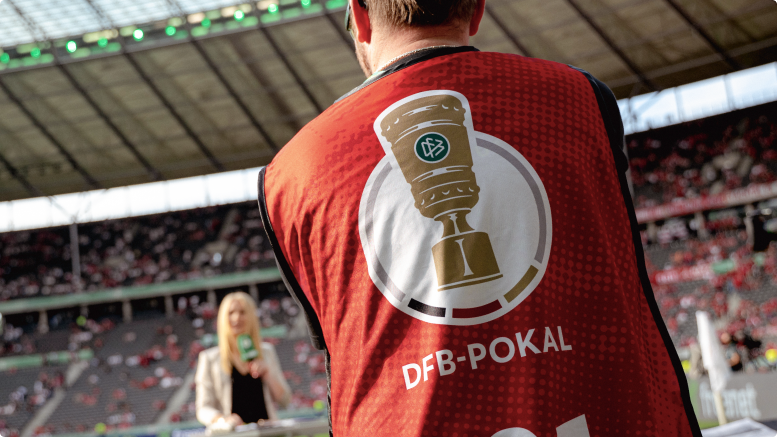 Rückenansicht einer Redaktionsweste im Stadion mit DFB-Pokal-Logo und dem Schriftzug DFB-Pokal. 