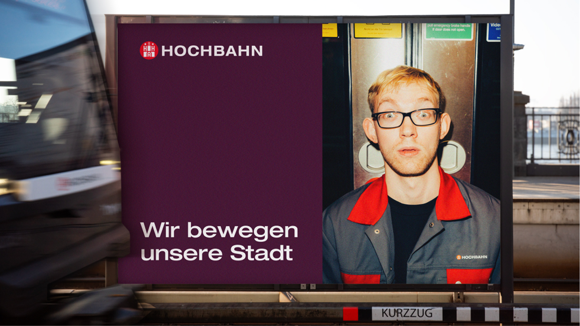 Hochbahn-Plakat: Mann in Arbeitskleidung vor Bahntür, Logo und Slogan „Wir bewegen unsere Stadt" auf Violett.