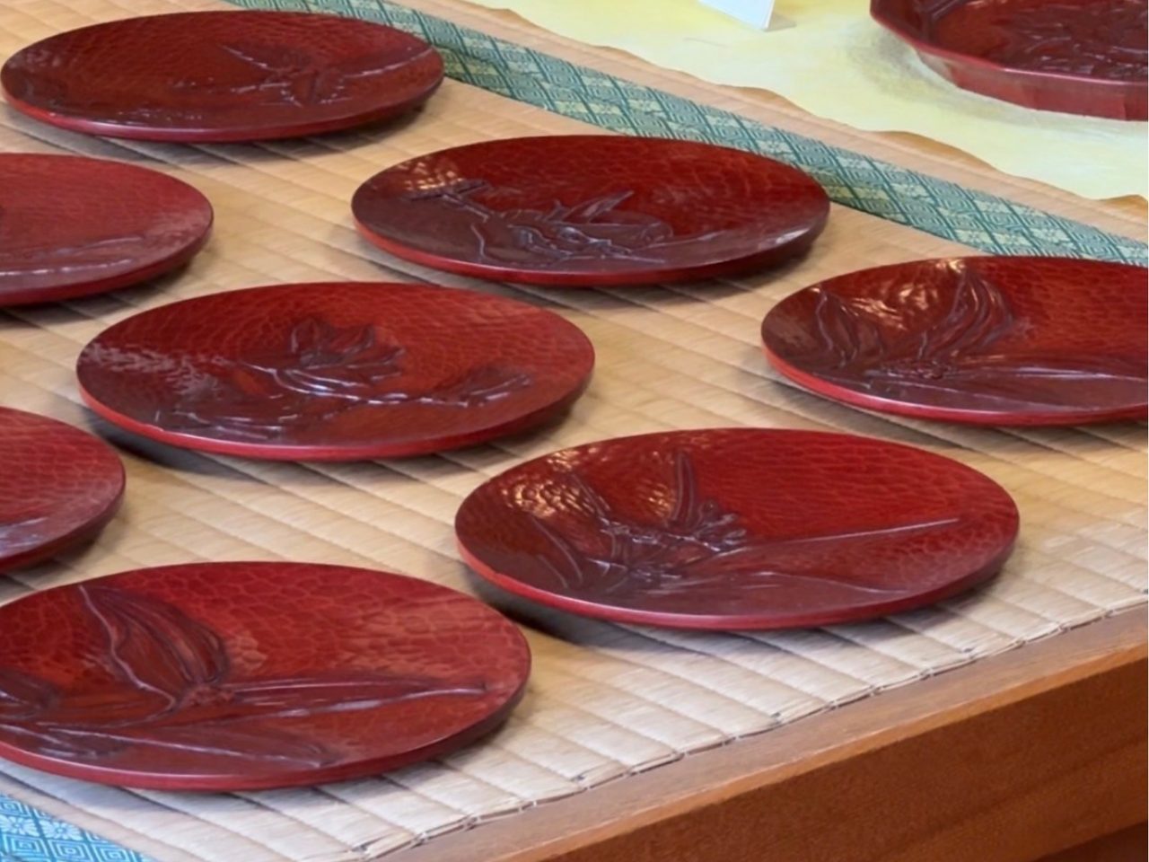 Red wooden lacquered plates on top of tatami mats