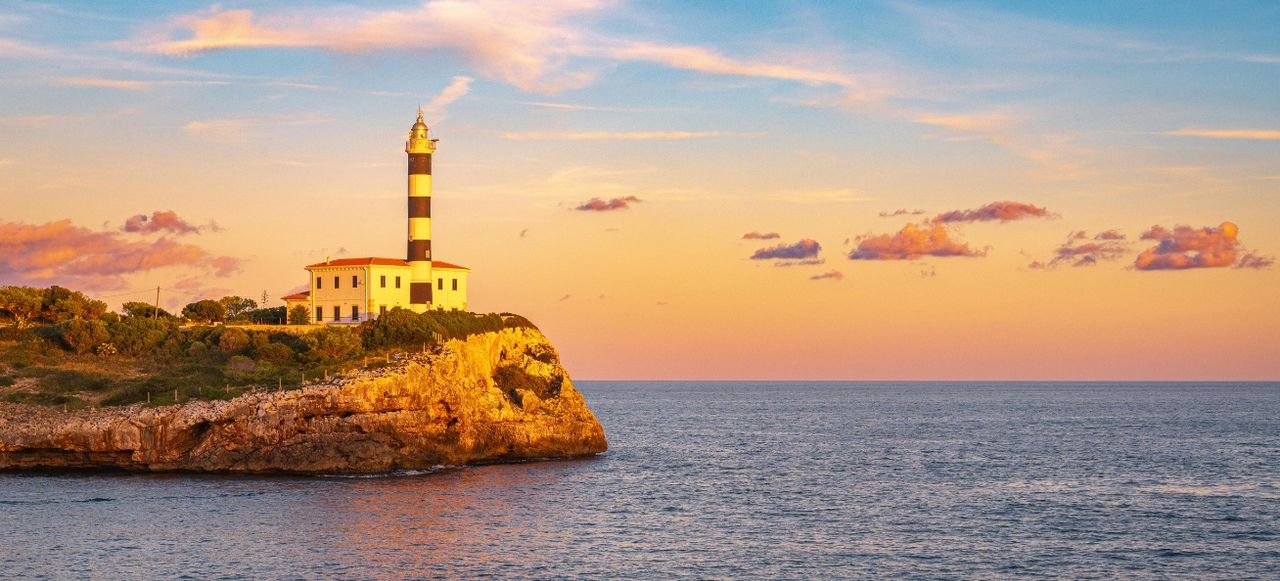 Lighthouse on Sea Shore at Sunset