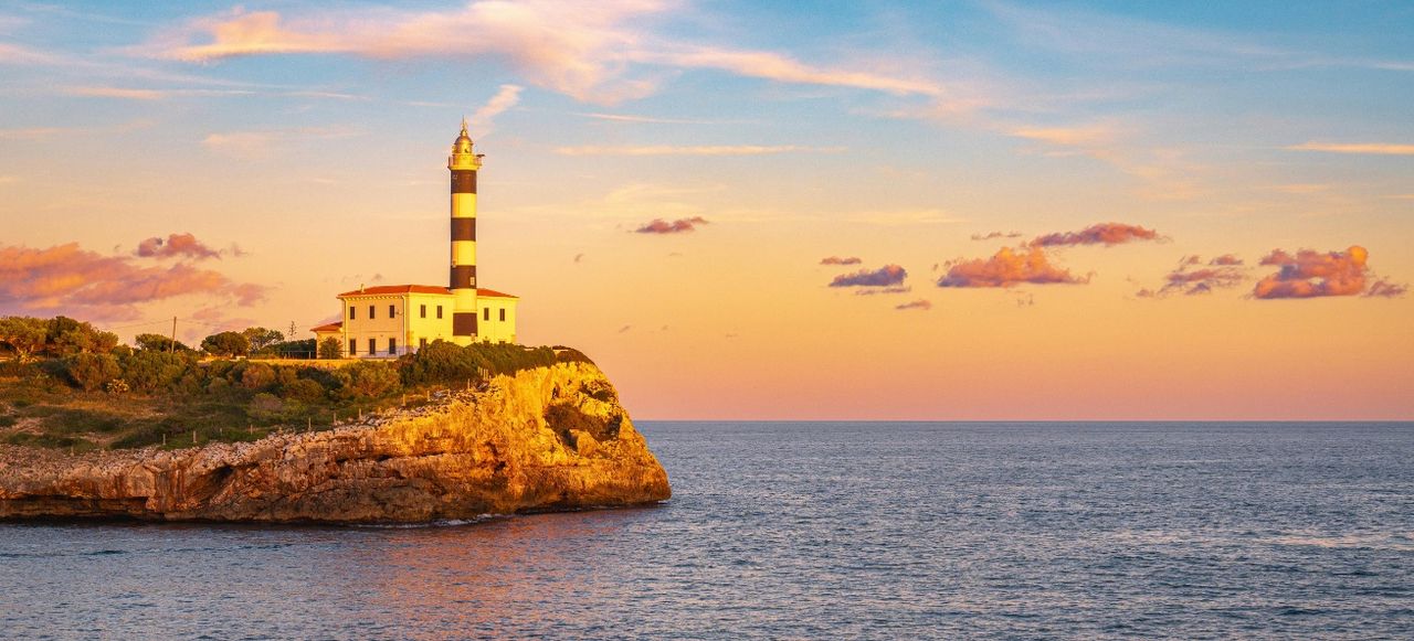Lighthouse on Sea Shore at Sunset