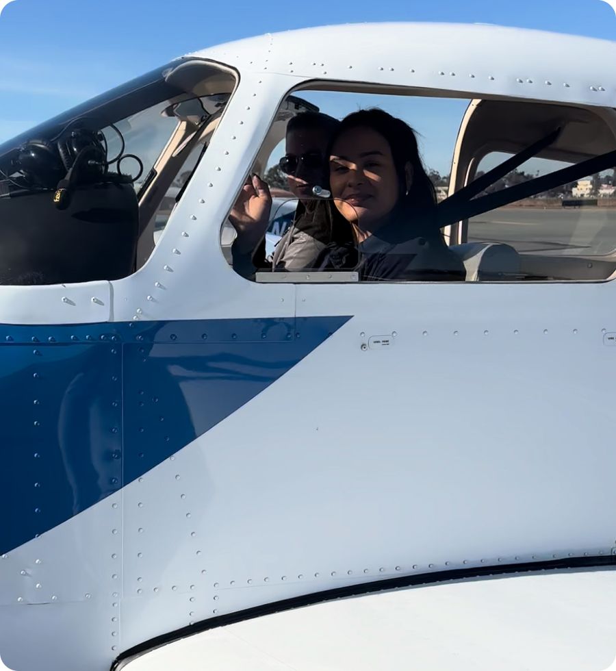 First-time student smiling from the cockpit of a Coast trainer