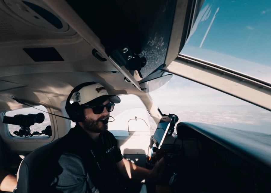 Coast pilot at the controls in flight, the city below through the window