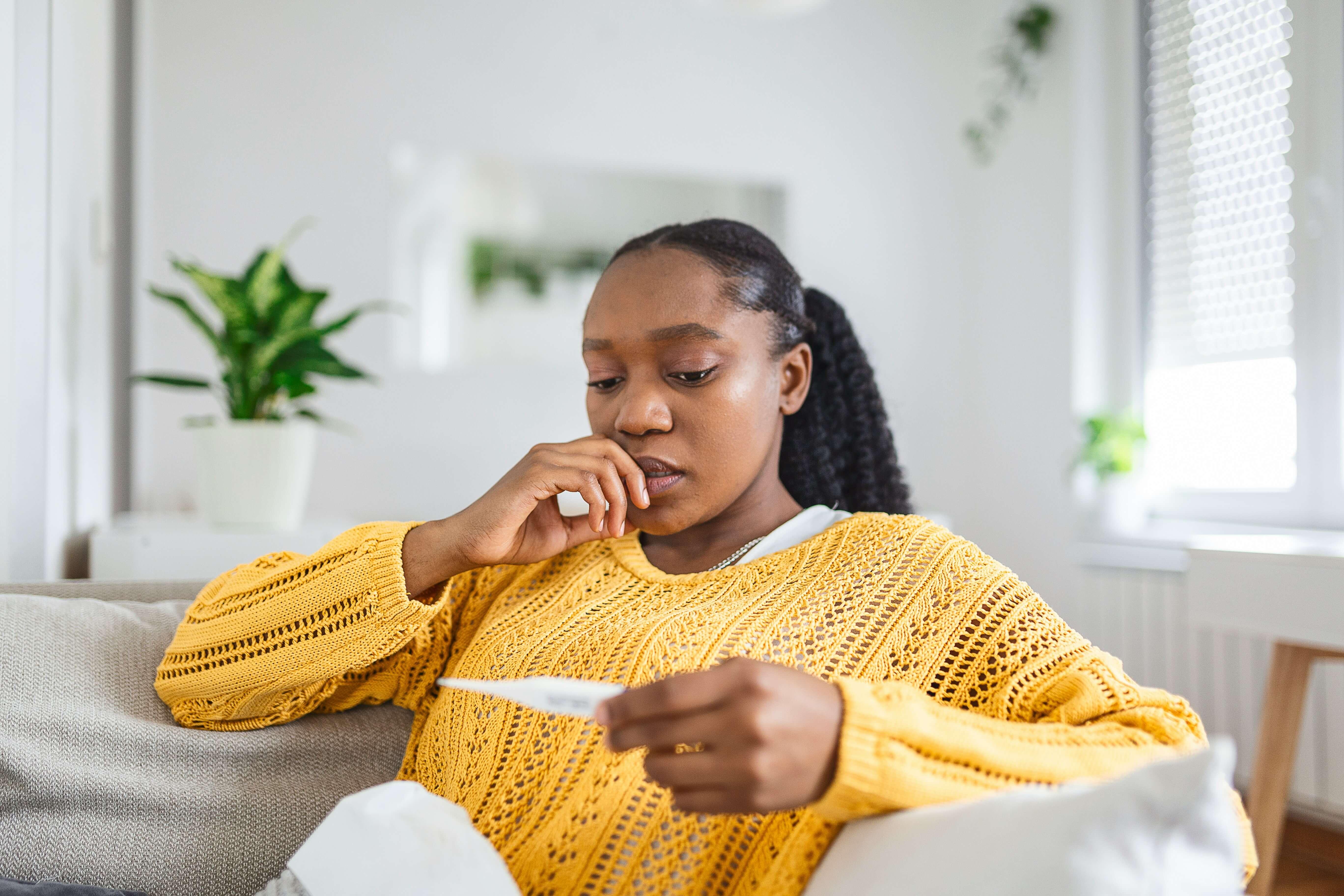 Woman Sitting on Sofa Reading Home Rapid Test