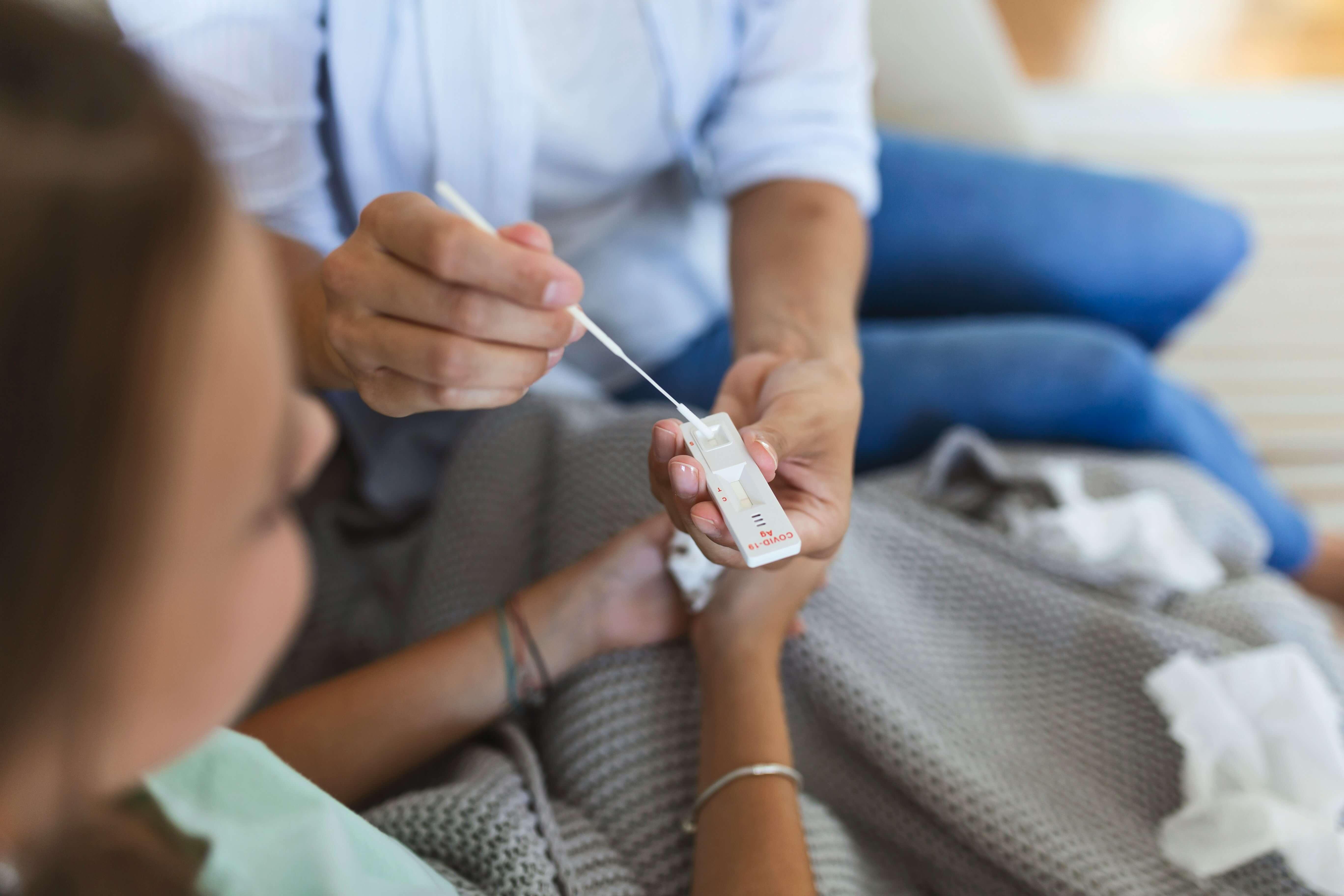 A nurse helping woman take rapid health test