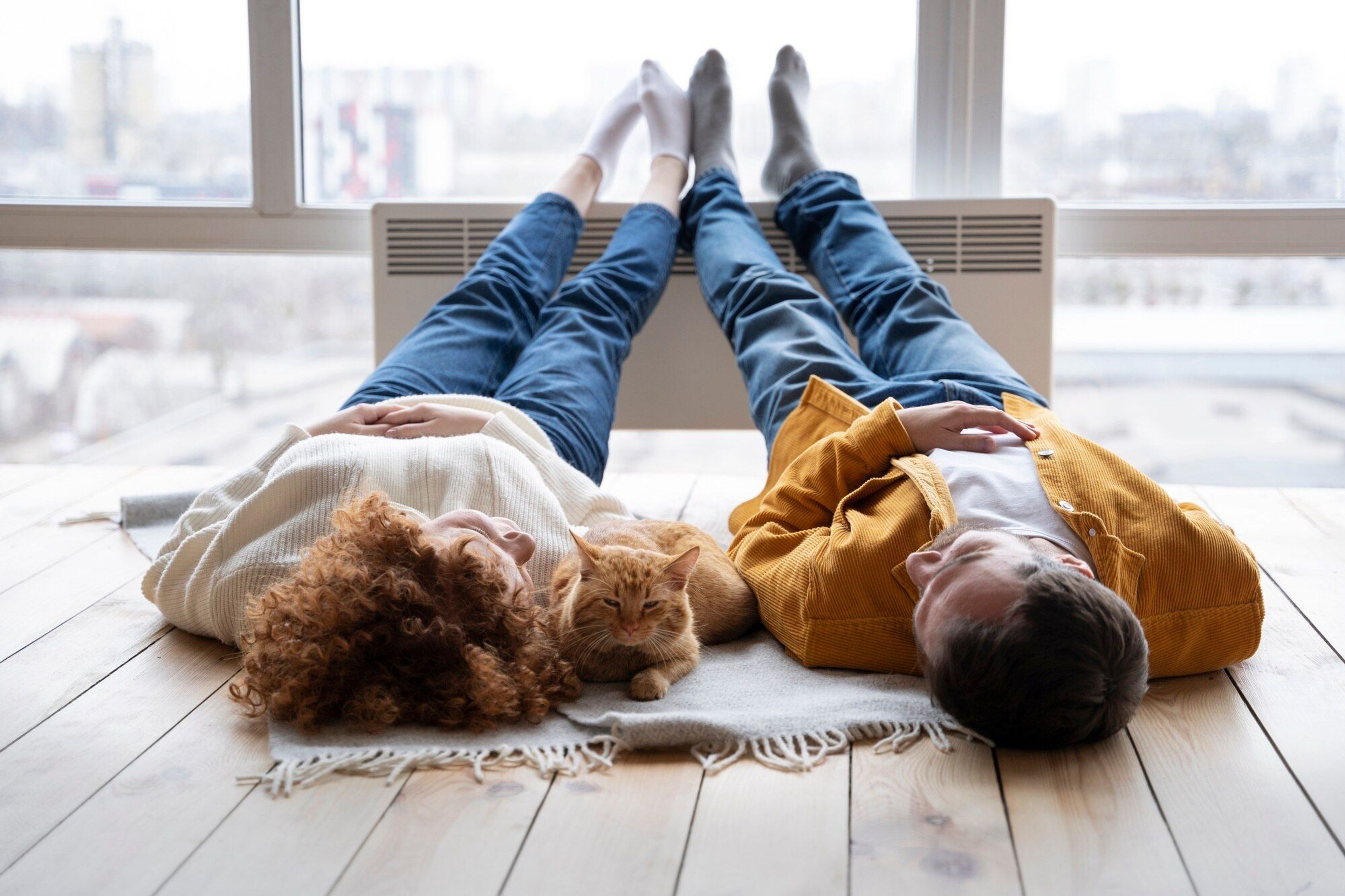 Fullt skudd kvinne og mann legger seg på teppe